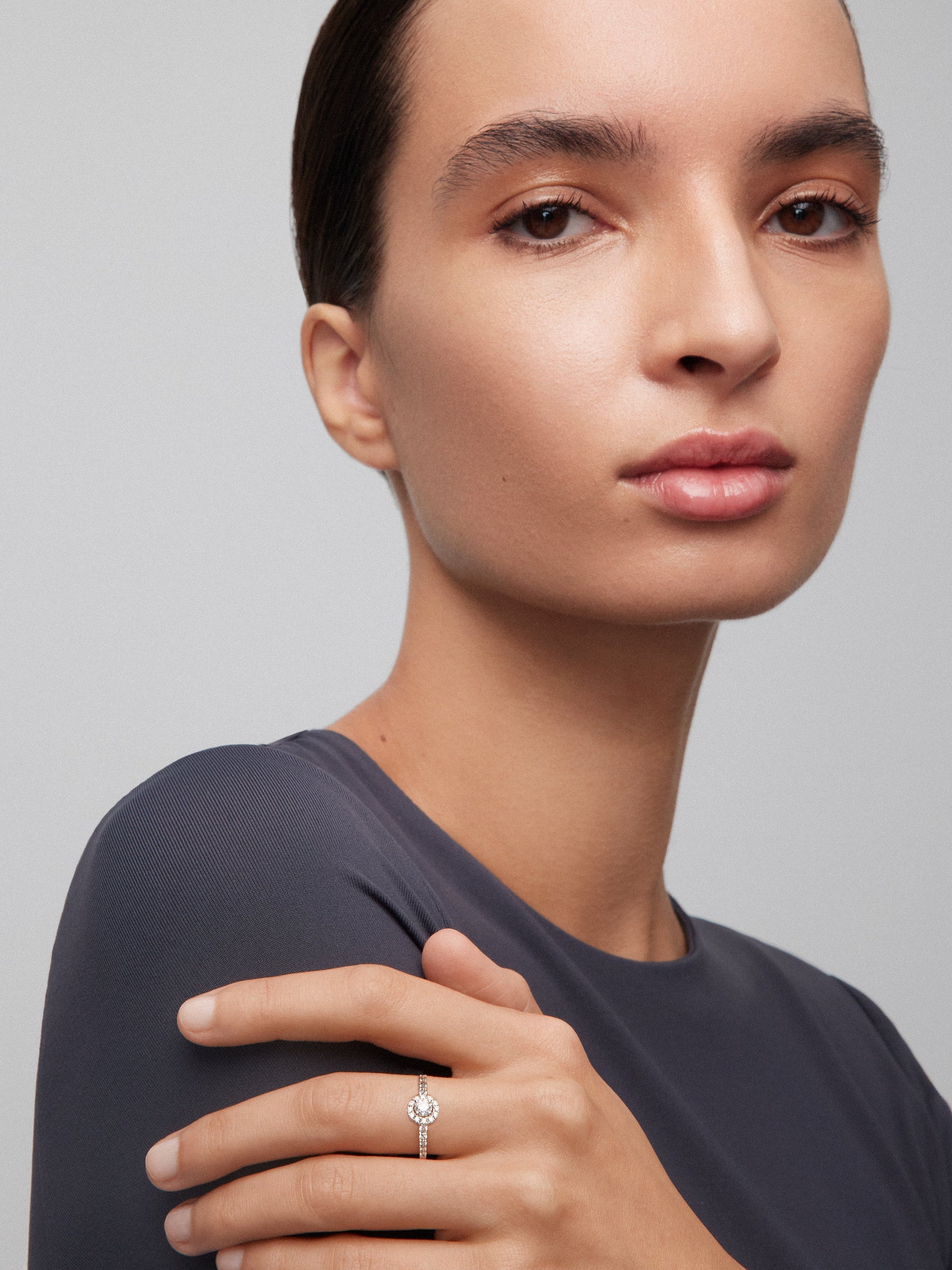 Anillo de oro blanco de 18K con diamante central en talla brillante de 0,25 cts y orla y brazo con 26 diamantes en talla brillante con un total de 0,35 cts