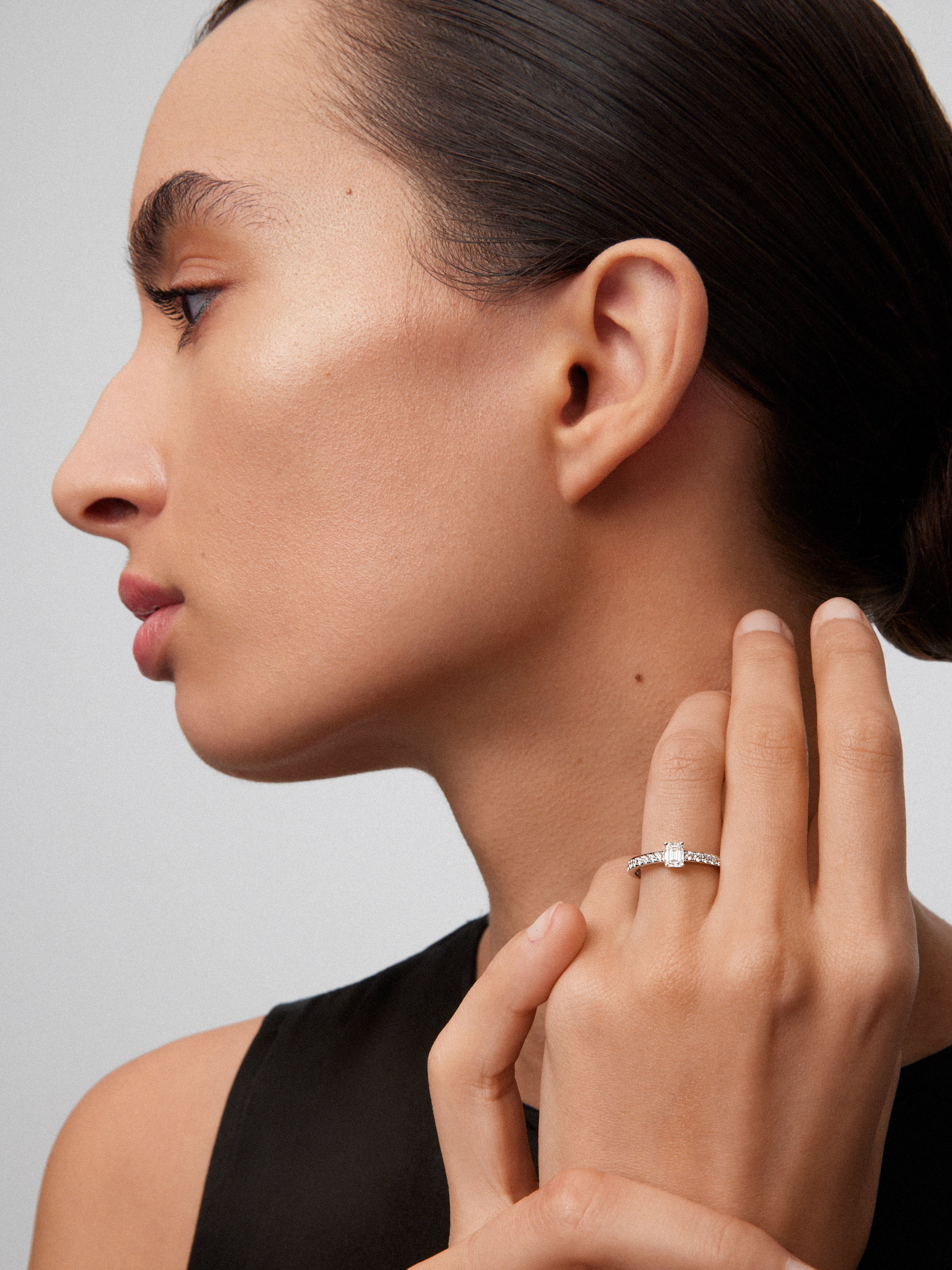 Anillo de oro blanco de 18K con diamante central en talla esmeralda de 0,4 cts y brazo de 26 diamantes en talla brillante con un total de 0,26 cts