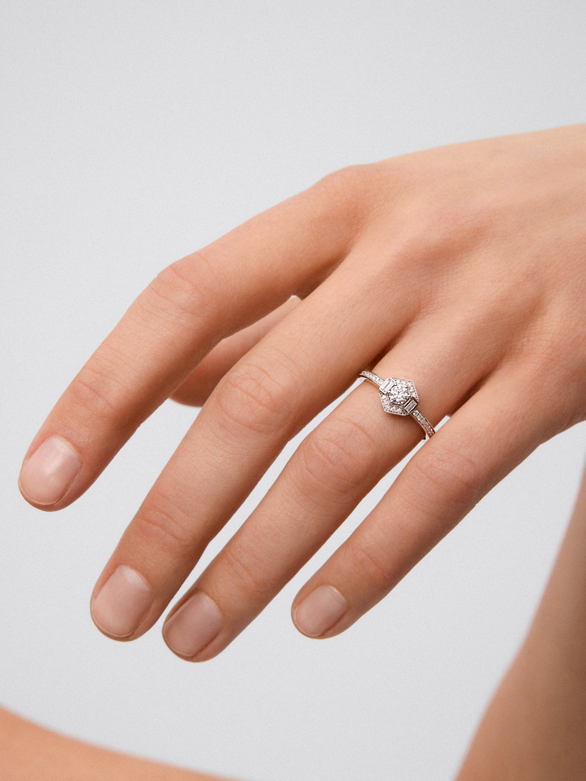 Anillo de oro blanco de 18K con un diamante central en talla brillante de 0,2 cts, 2 en talla baguette con un total de 0,05 cts y 38 en talla brillante con un total de 0,12 cts