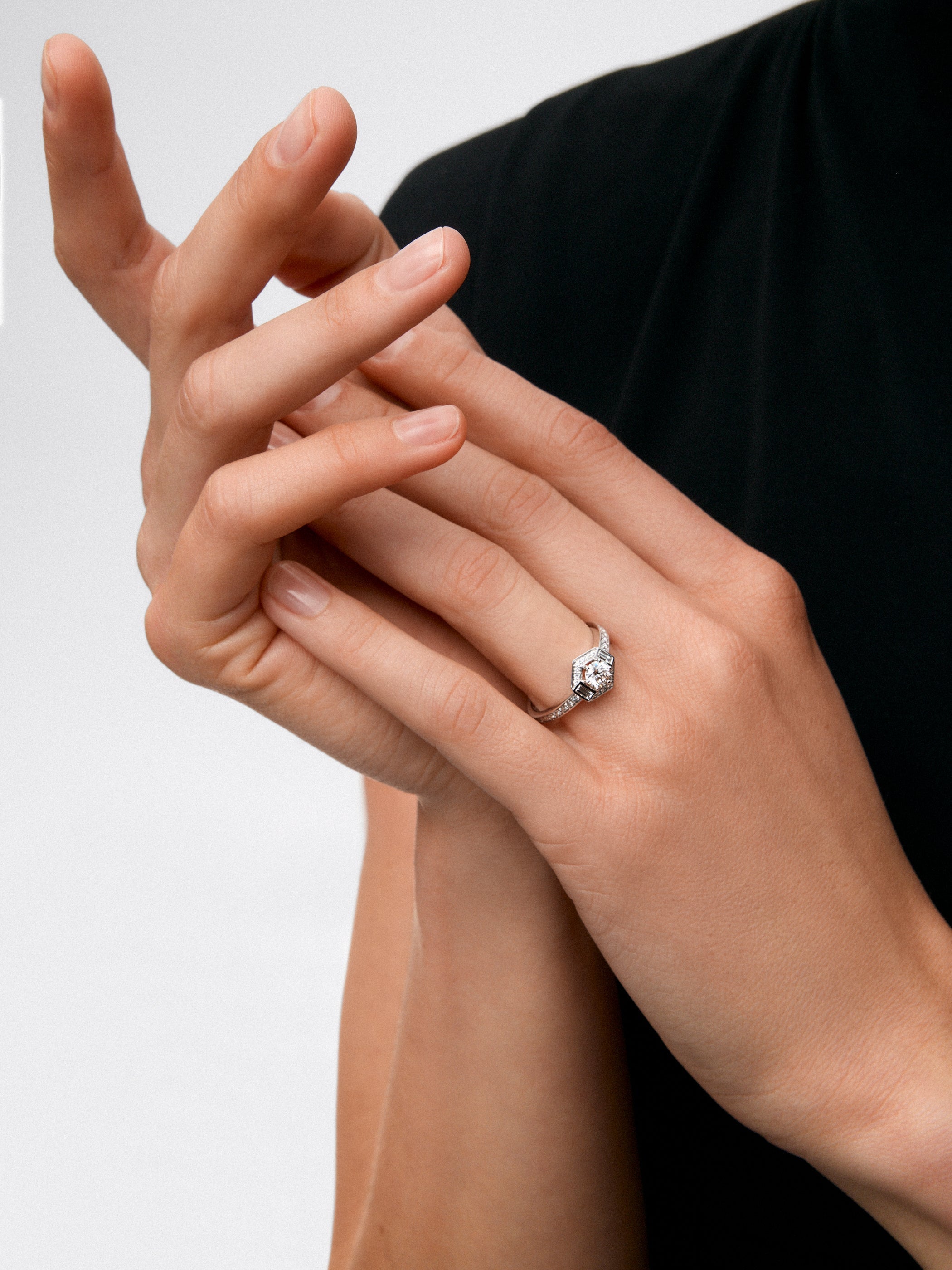 Anillo de oro blanco de 18K con diamante central en talla brillante de 0,4 cts y orla con 2 diamantes en talla baguette con un total de 0,14 cts y 30 en talla brillante con un total de 0,19 cts