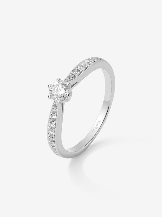 Anillo solitario 3006 de oro blanco de 18K con diamante central en talla brillante de 0,20 cts y diamantes en talla brillante con un total de 0,10 cts