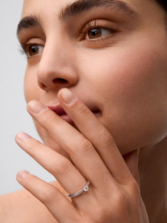 Anillo solitario 3006 de oro blanco de 18K con diamante central en talla brillante de 0,20 cts y diamantes en talla brillante con un total de 0,10 cts