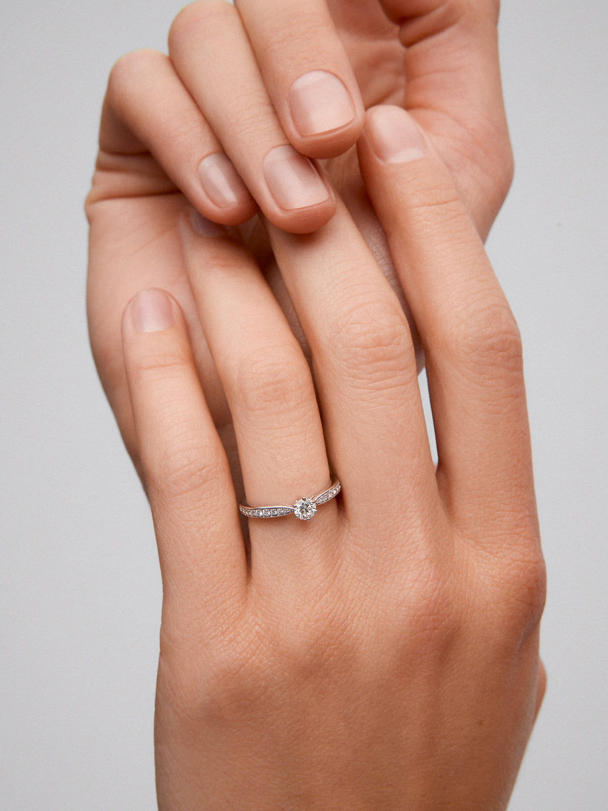 Anillo solitario 3006 de oro blanco de 18K con diamante central en talla brillante de 0,20 cts y diamantes en talla brillante con un total de 0,10 cts