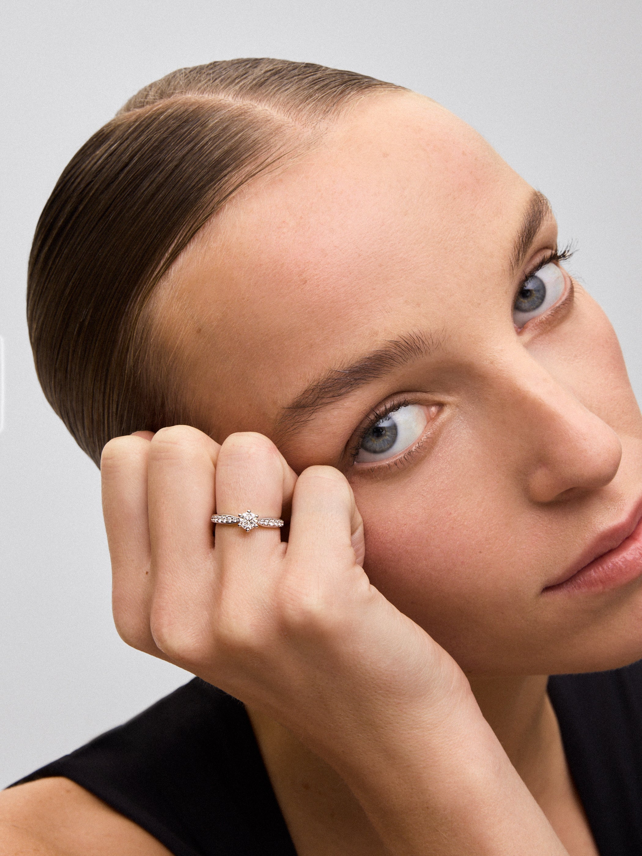Anillo solitario de oro blanco de 18K con diamante central en talla brillante de 0,50 cts y diamantes en talla brillante con un total de 0,23 cts