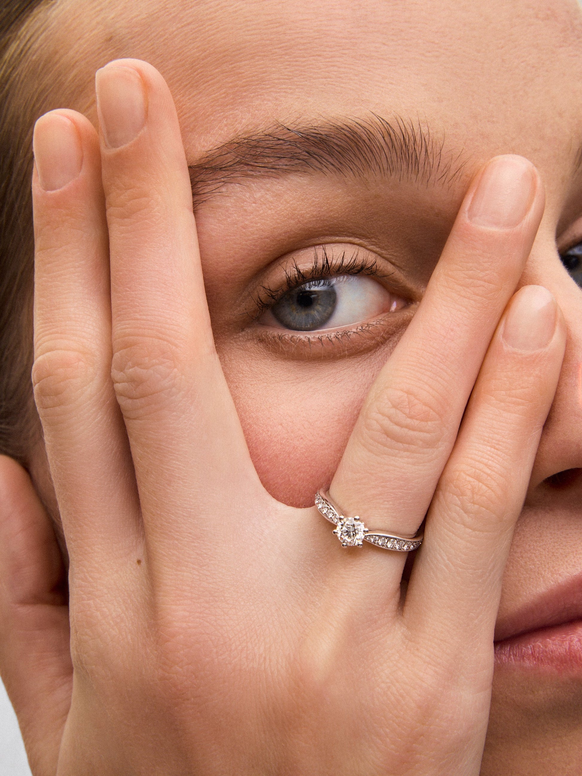 Anillo solitario de oro blanco de 18K con diamante central en talla brillante de 0,50 cts y diamantes en talla brillante con un total de 0,23 cts