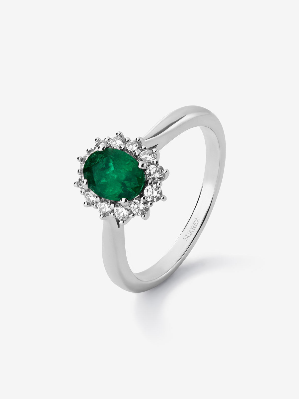 Anillo de oro blanco de 18K con esmeralda central en talla oval de 0,70 cts y orla de diamantes en talla brillante con un total de 0,30 cts
