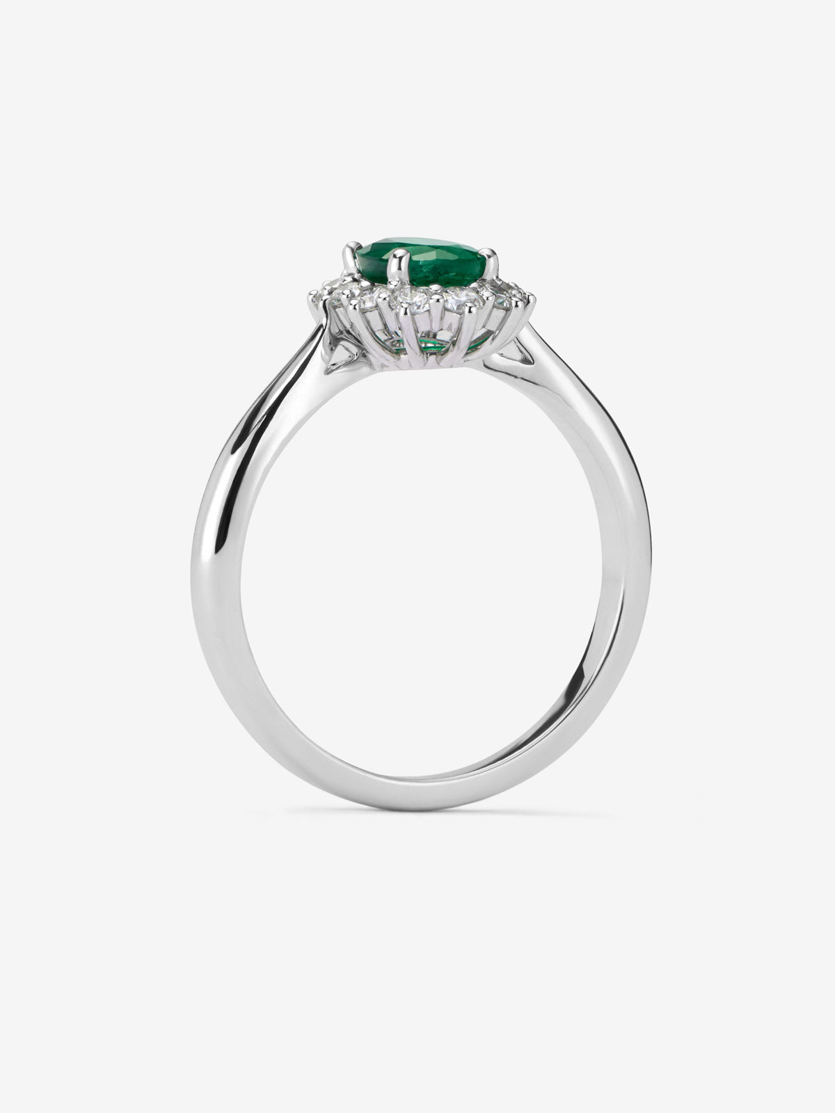 Anillo de oro blanco de 18K con esmeralda central en talla oval de 0,76 cts y orla de diamantes en talla brillante con un total de 0,45 cts
