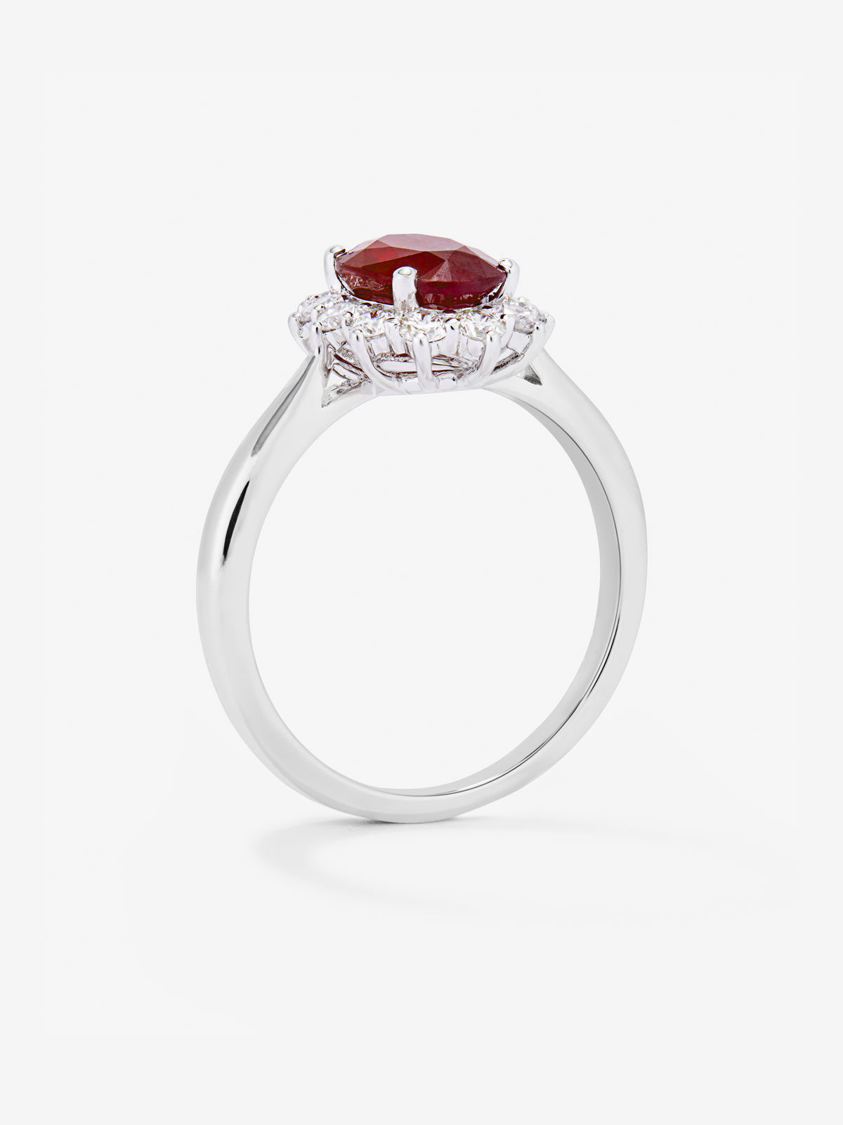 Anillo de oro blanco de 18K con rubí rojo vivid en talla oval de 1 cts y 12 diamantes en talla brillante con un total de 0,25 cts