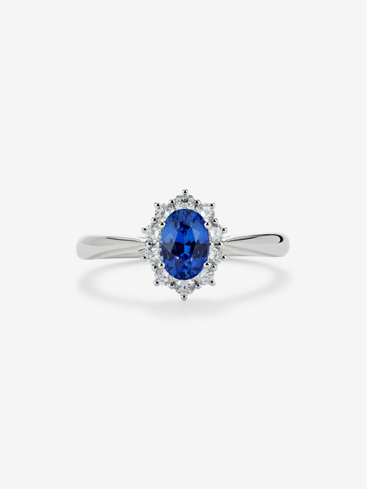 Anillo de oro blanco de 18K con zafiro azul central en talla oval de 0,4 cts y orla de diamantes en talla brillante con un total de 0,25 cts