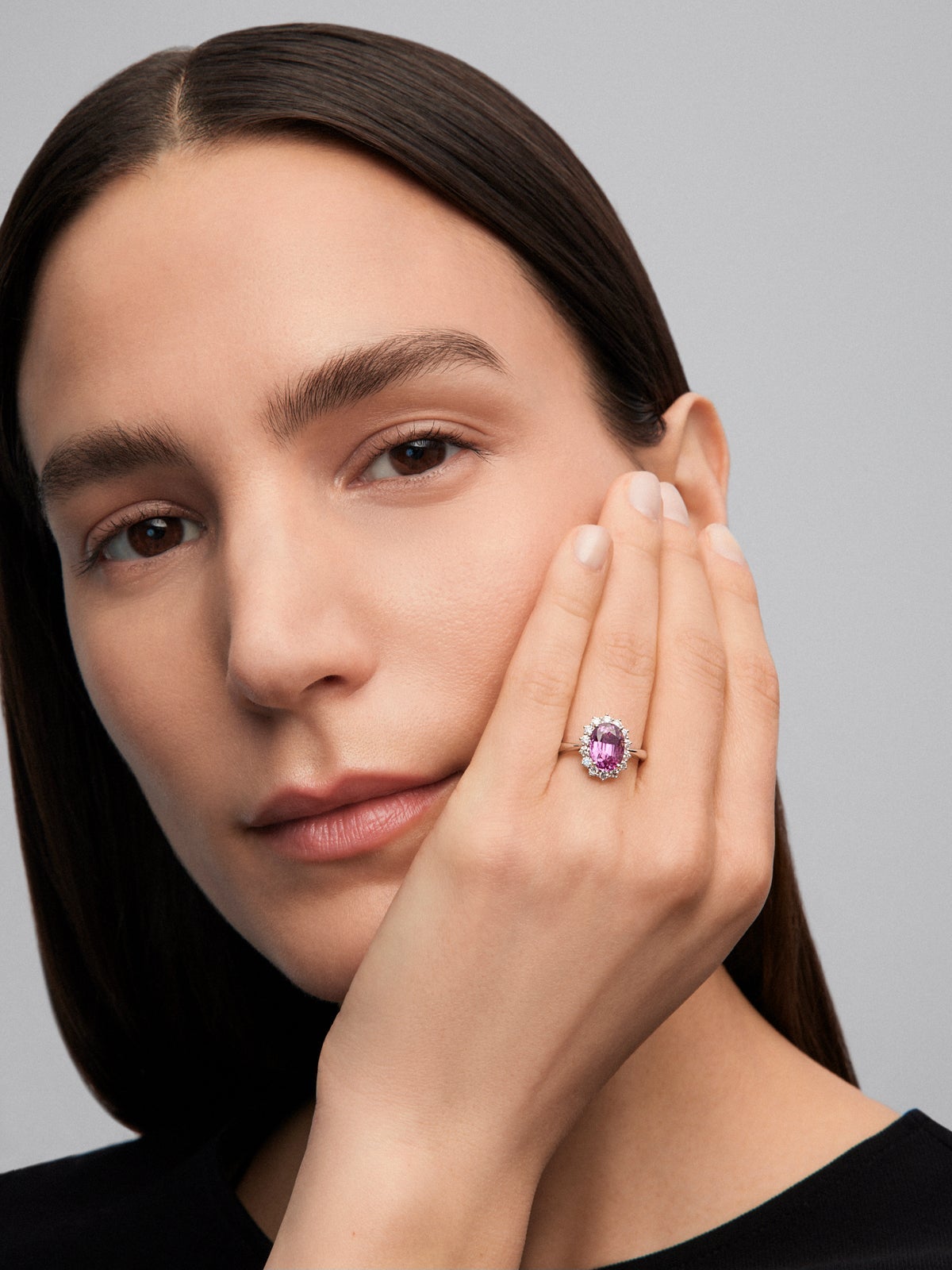 Anillo de oro blanco de 18K con zafiro rosa en talla oval de 0,55 cts y 12 diamantes en talla brillante con un total de 0,1 cts
