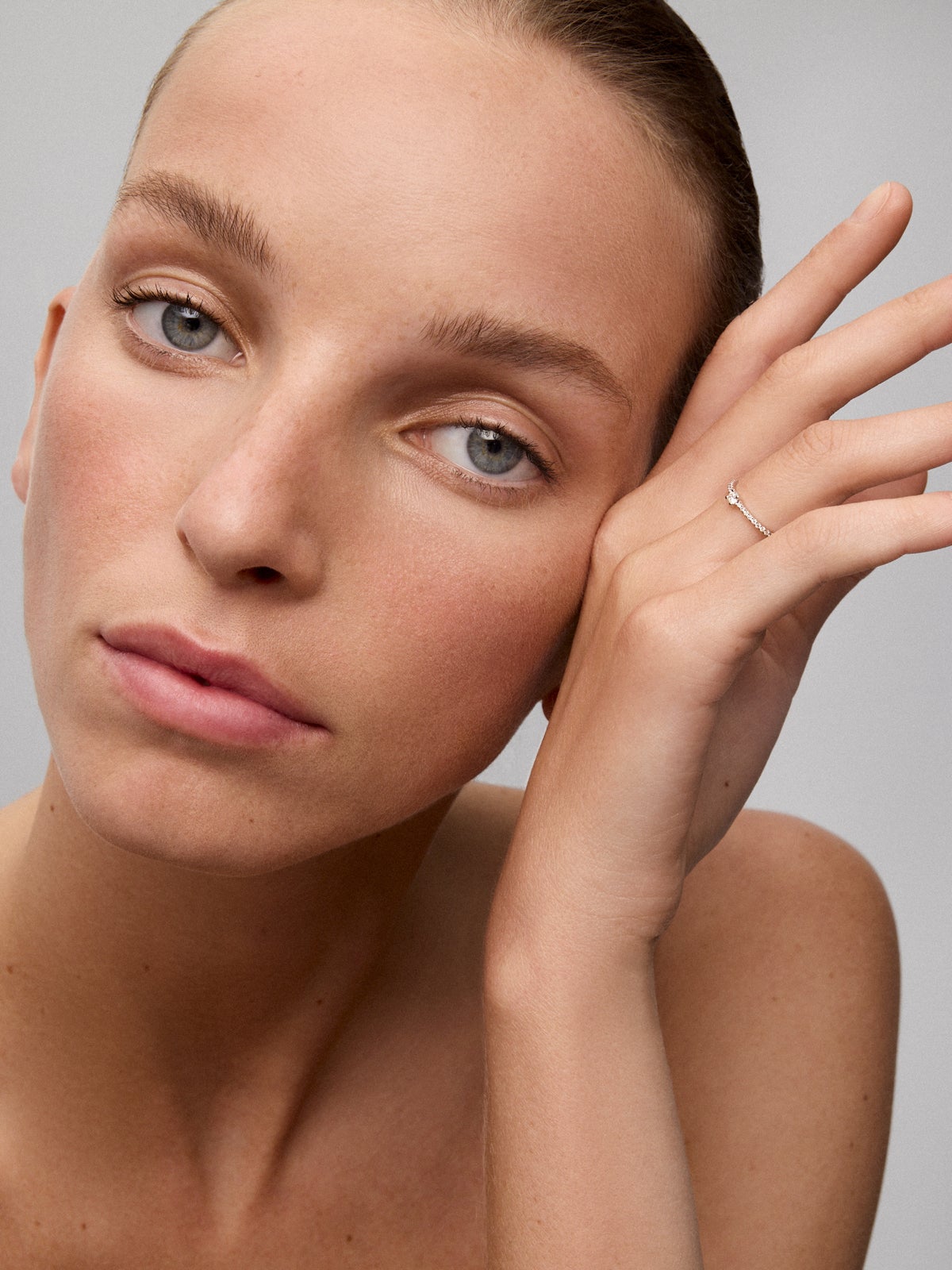 Anillo de oro blanco de 18K con diamante central en talla brillante de 0,12 cts y brazo de 20 diamantes en talla brillante con un total de 0,11 cts