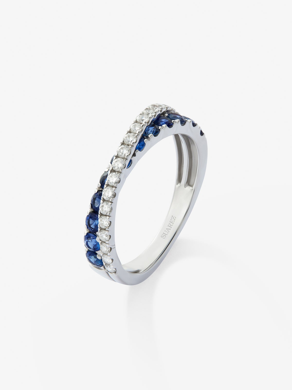 Anillo cruzado de oro blanco de 18K con 12 zafiros con un total de 0,68 cts y 20 diamantes en talla brillante con un total de 0,20 cts