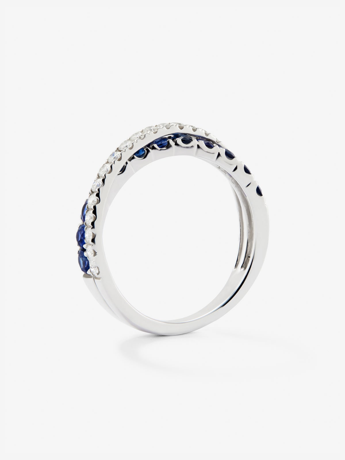 Anillo cruzado de oro blanco de 18K con 12 zafiros con un total de 0,8 cts y 20 diamantes en talla brillante con un total de 0,28 cts