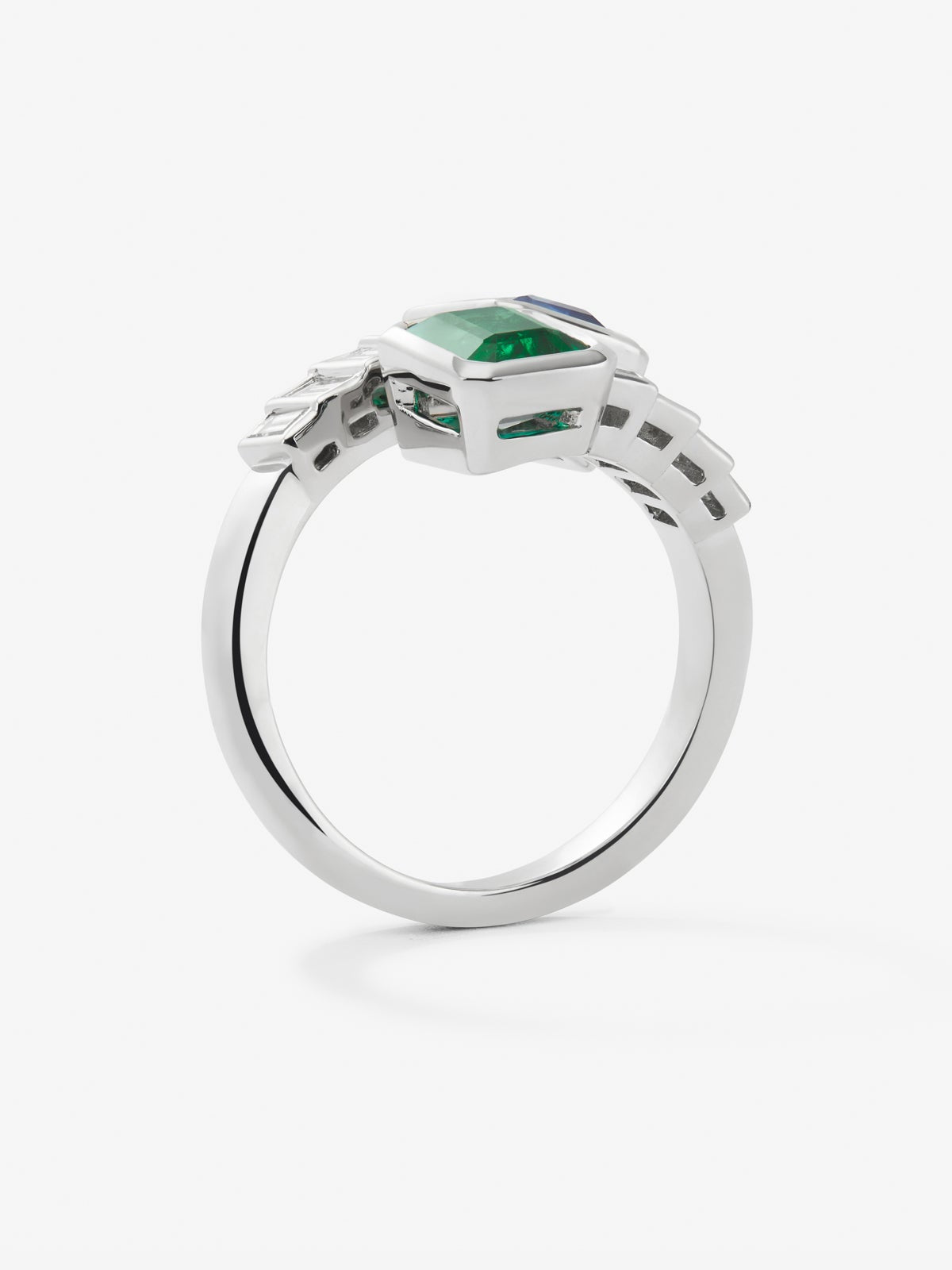 Anillo tú y yo de oro blanco de 18K con un zafiro azul en talla octogonal de 1,64 cts, una esmeralda verde en talla octogonal de 1,02 cts y 8 diamantes en talla baguette con un total de 0,72 cts