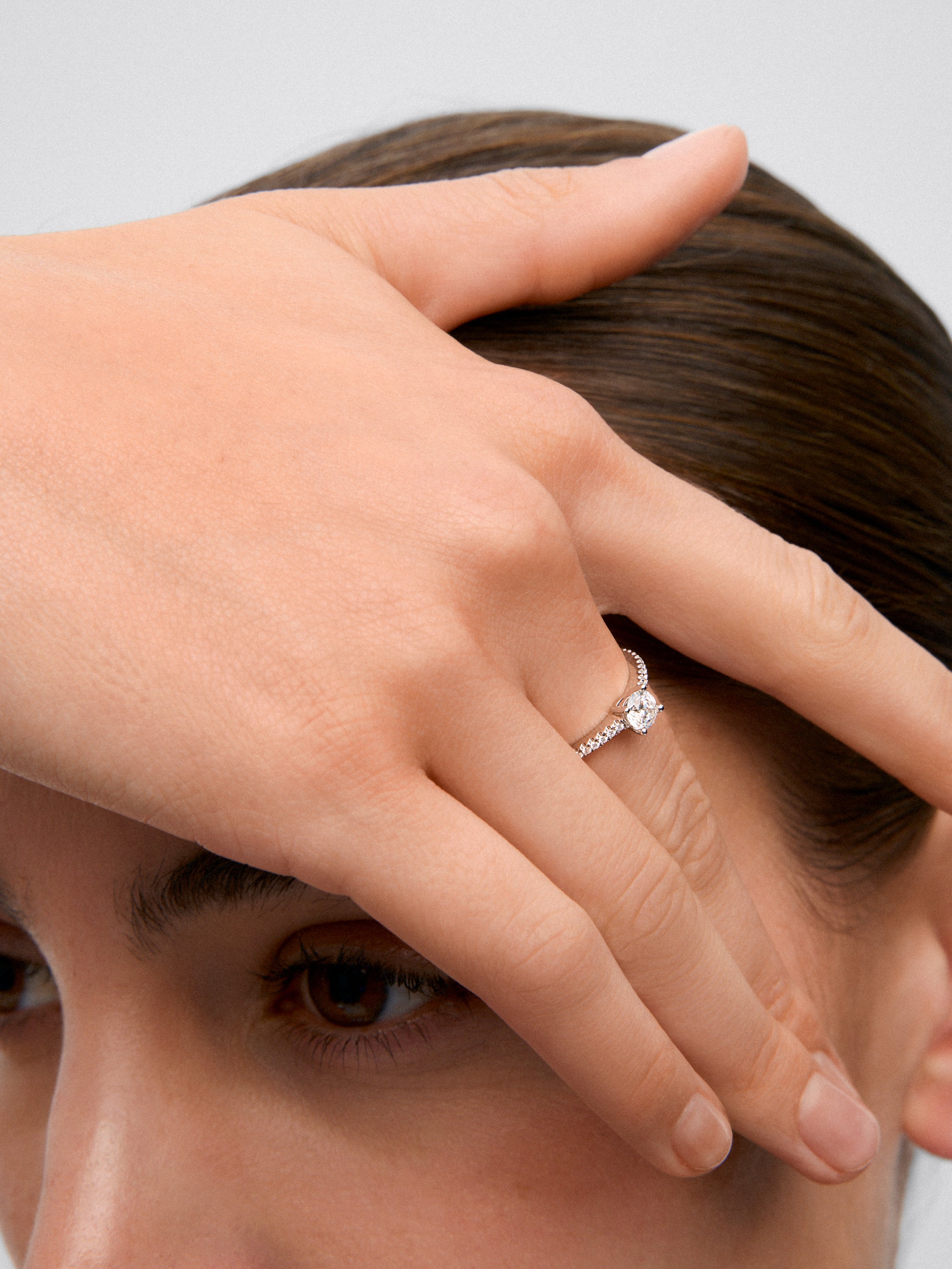 Anillo solitario de oro blanco de 18K con diamante central en talla brillante de 0,4 cts y brazo de 22 diamantes en talla brillante con un total de 0,1 cts