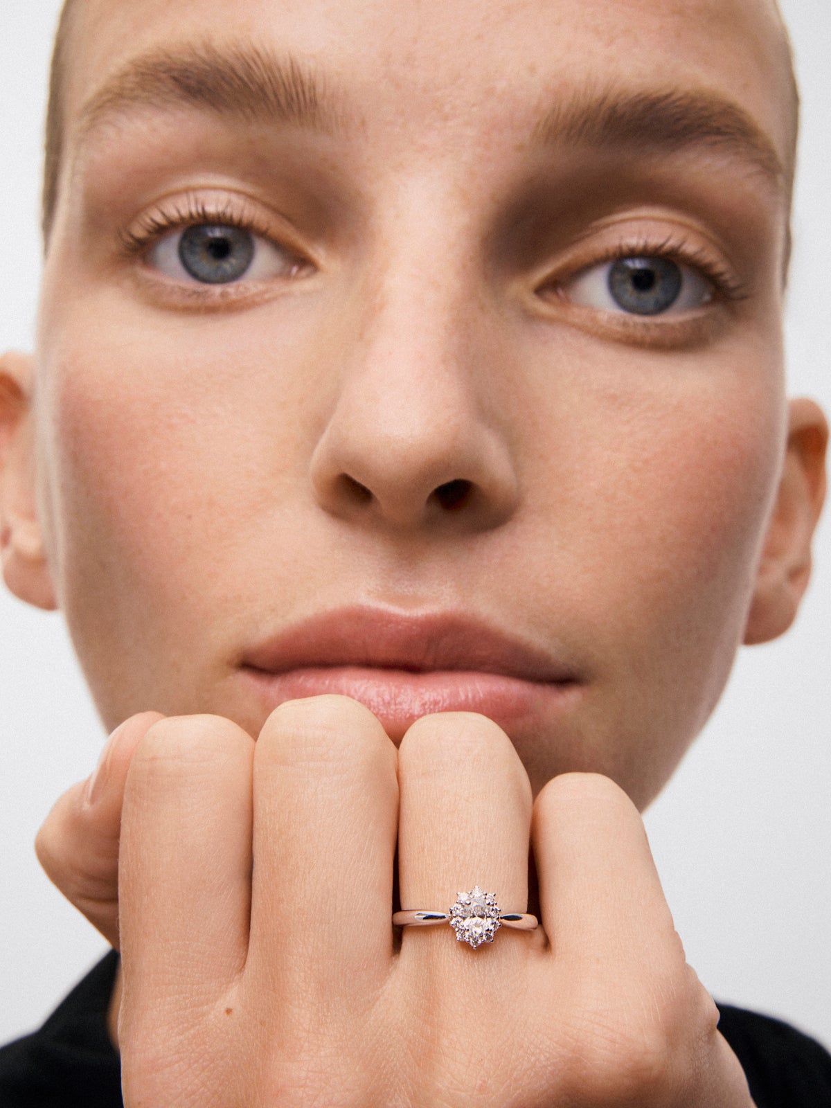 Anillo solitario de oro blanco de 18K con diamante central en talla oval de 0,3 cts y orla de 10 diamantes en talla brillante con un total de 0,18 cts