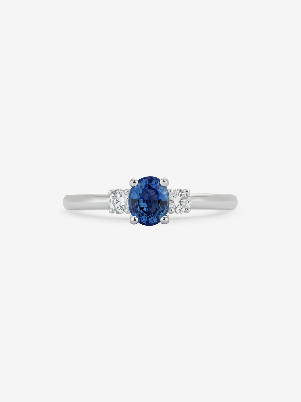 Anillo tresillo de oro blanco de 18K con zafiro azul en talla oval de 0,69 cts y 2 diamantes en talla brillante con un total de 0,16 cts