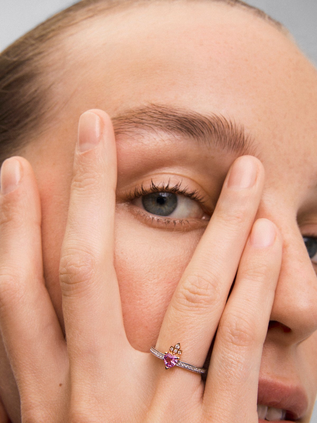 Anillo de oro blanco y rosa de 18K con zafiro rosa en talla corazón de 0,4 cts y 26 diamantes en talla brillante con un total de 0,132 cts