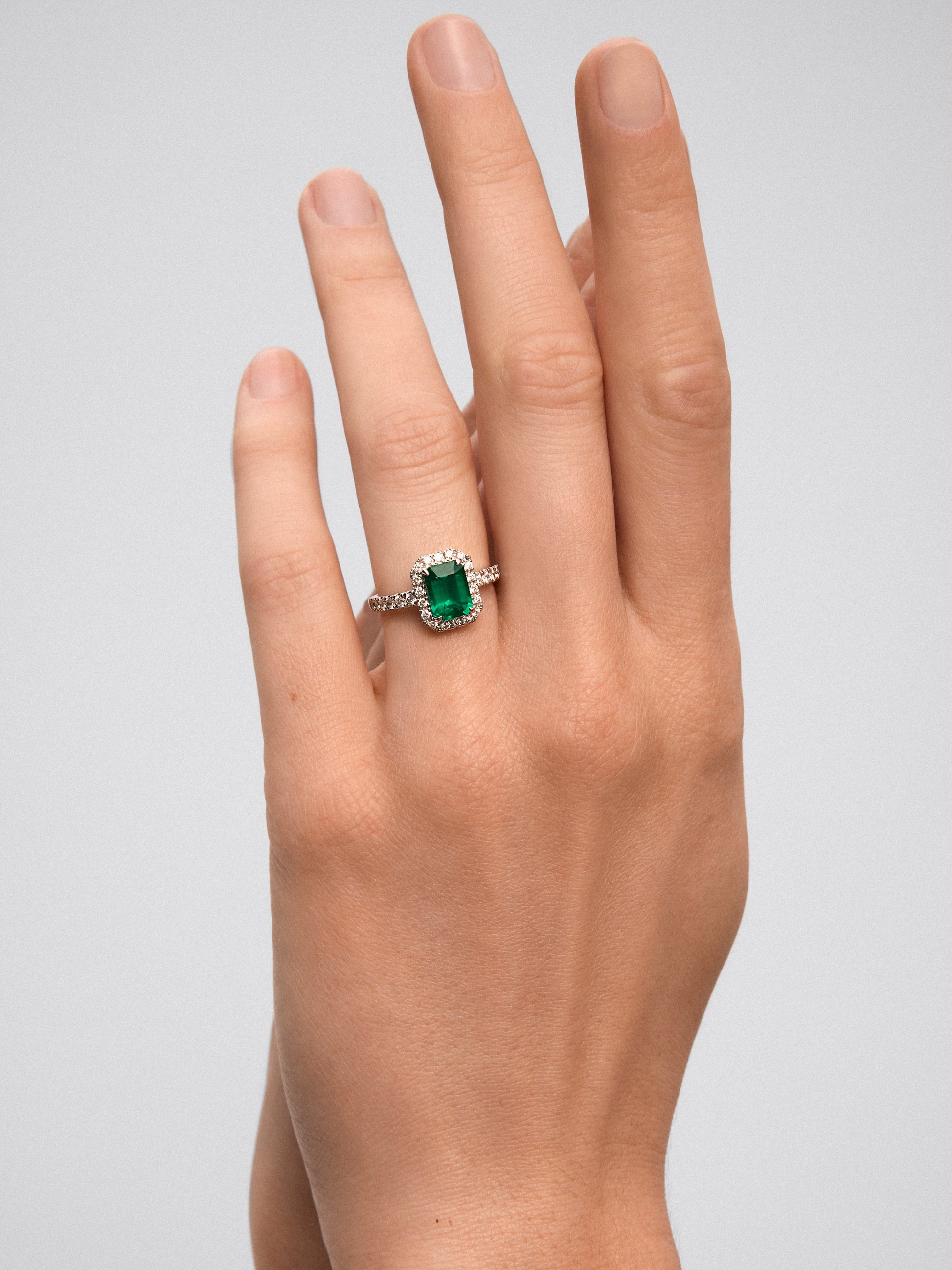 Anillo de oro blanco de 18K con esmeralda verde en talla octogonal de 1,67 cts y orla y brazo de 30 diamantes en talla brillante con un total de 0,43 cts