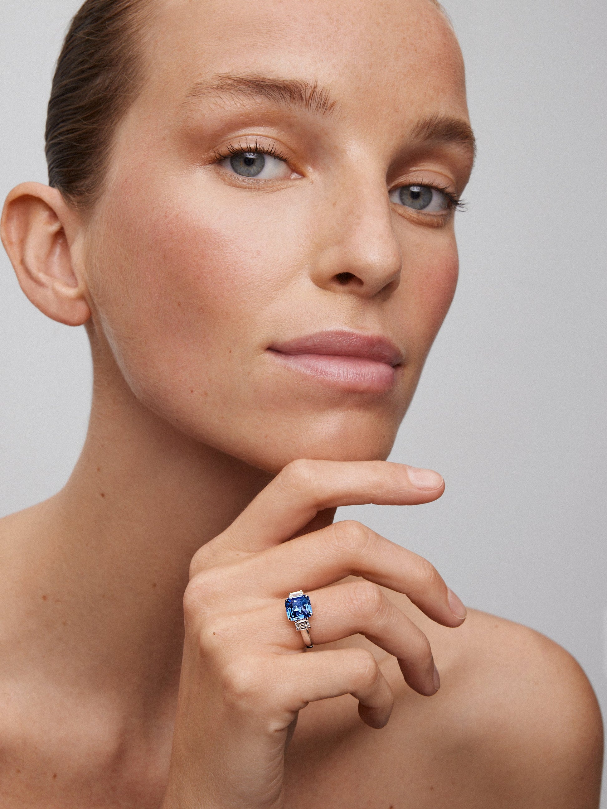 Anillo tresillo de oro blanco de 18K con zafiro azul en talla esmeralda de 4,07 cts y 2 diamantes en talla esmeralda con un total de 0,81 cts