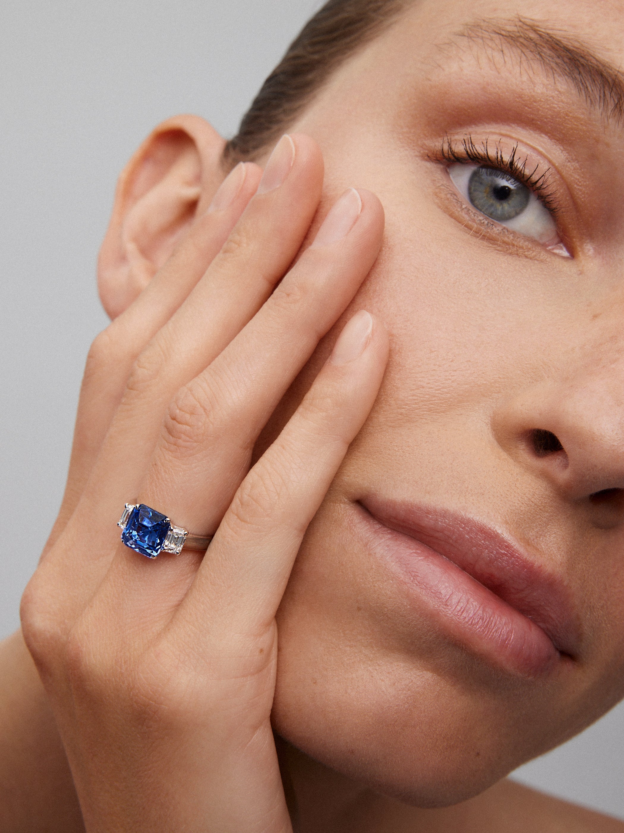 Anillo tresillo de oro blanco de 18K con zafiro azul en talla esmeralda de 4,07 cts y 2 diamantes en talla esmeralda con un total de 0,81 cts