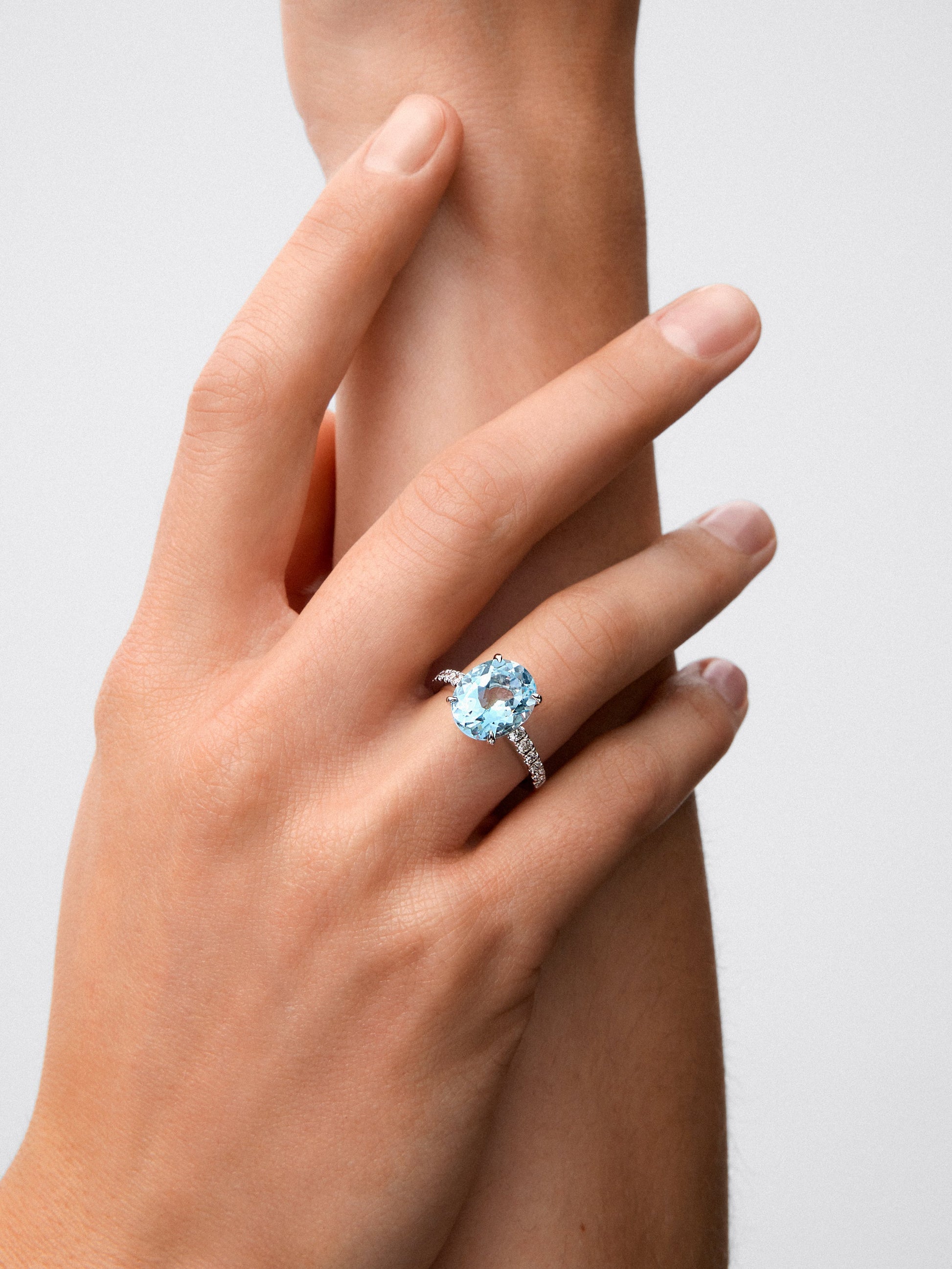 Anillo de oro blanco de 18K con topacio azul sky en talla oval de 5,8 cts y 12 diamantes en talla brillante con un total de 0,3 cts