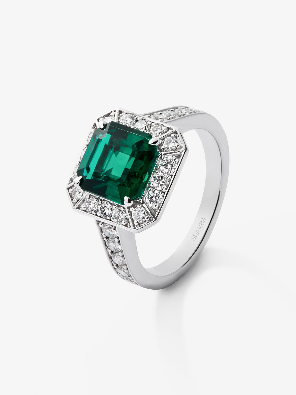Anillo de oro blanco de 18K con esmeralda en talla esmeralda de 2,6 cts y orla y brazo de 26 diamantes en talla brillante con un total de 0,7 cts