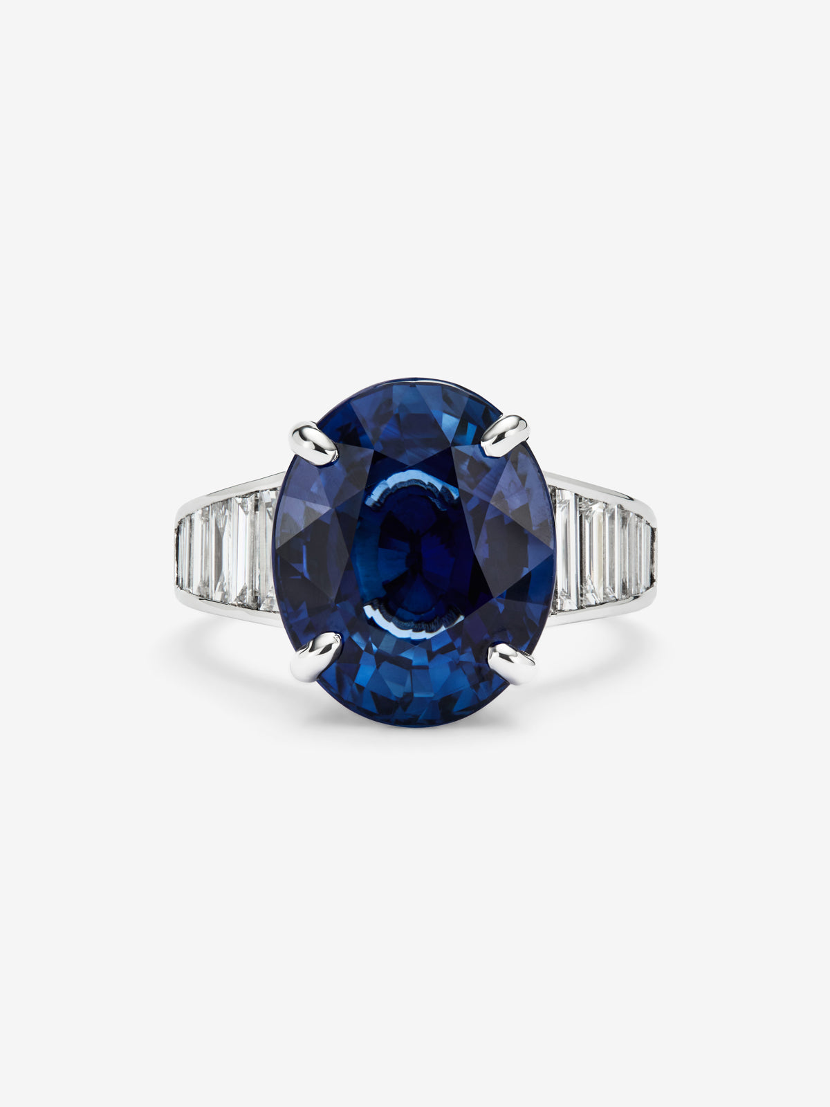 Anillo de oro blanco de 18K con zafiro azul en talla oval de 11,18 cts y 16 diamantes en talla baguette con un total de 1,27 cts
