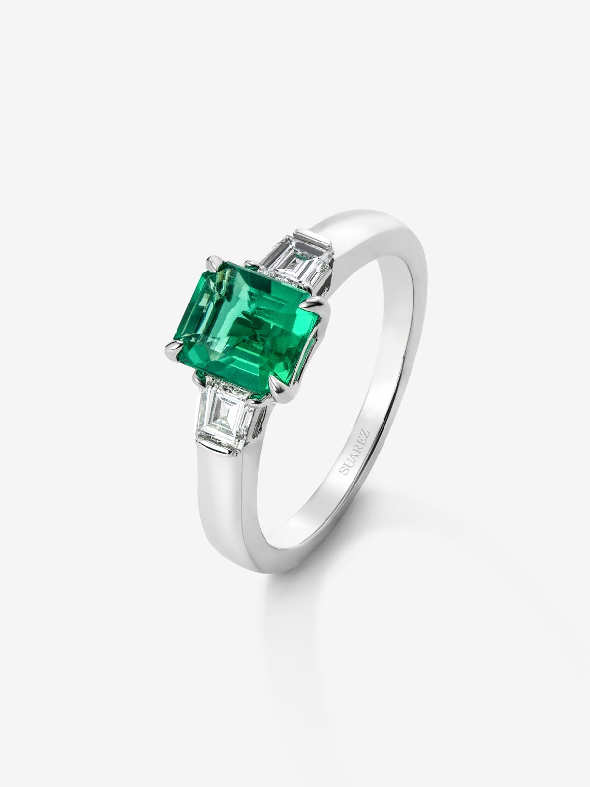 Anillo tresillo de oro blanco de 18K con esmeralda verde vivid en talla esmeralda de 1,64 cts y 2 diamantes blancos en talla fantasía con un total de 0,4 cts
