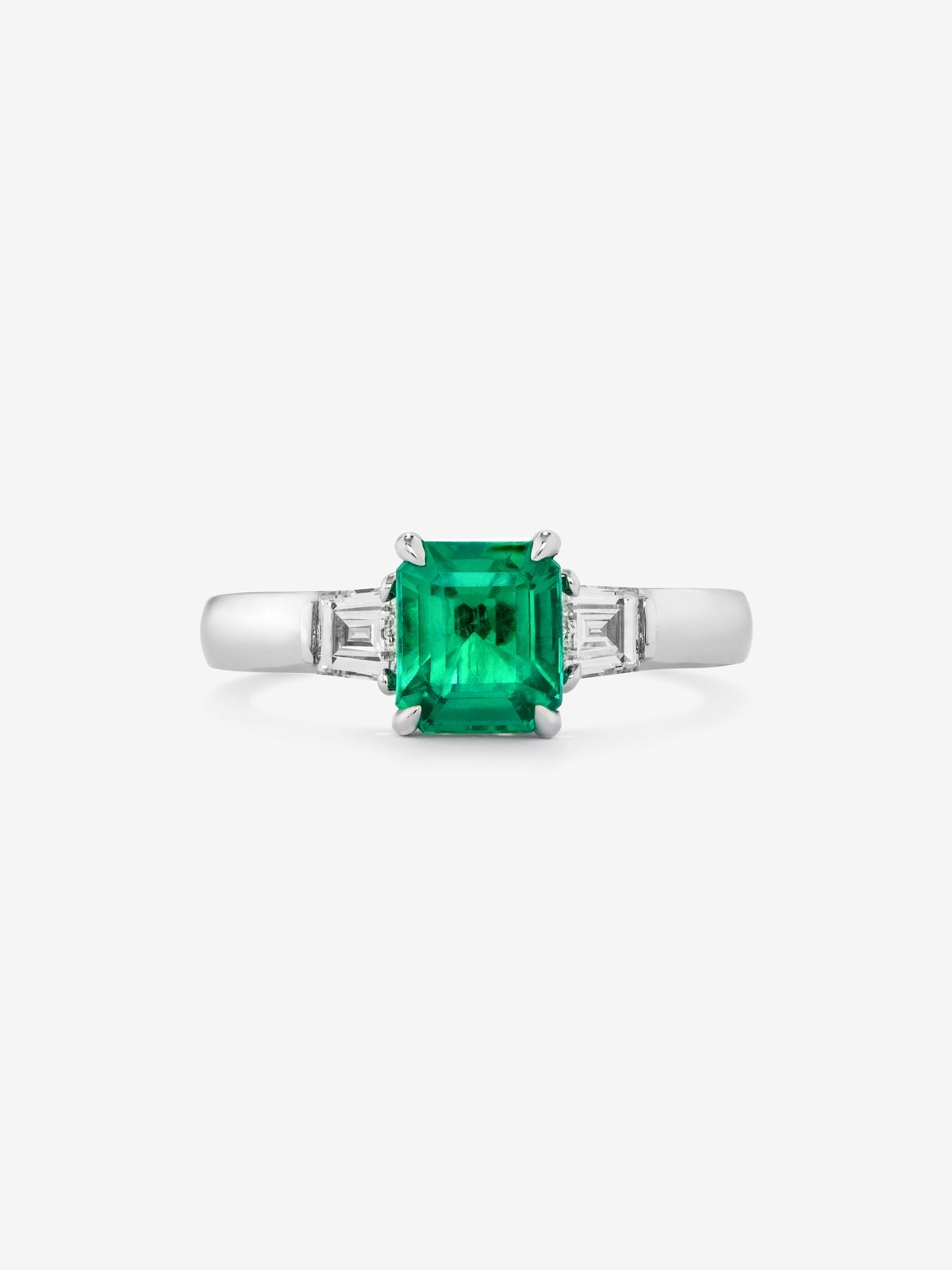 Anillo tresillo de oro blanco de 18K con esmeralda verde vivid en talla esmeralda de 1,64 cts y 2 diamantes blancos en talla fantasía con un total de 0,4 cts