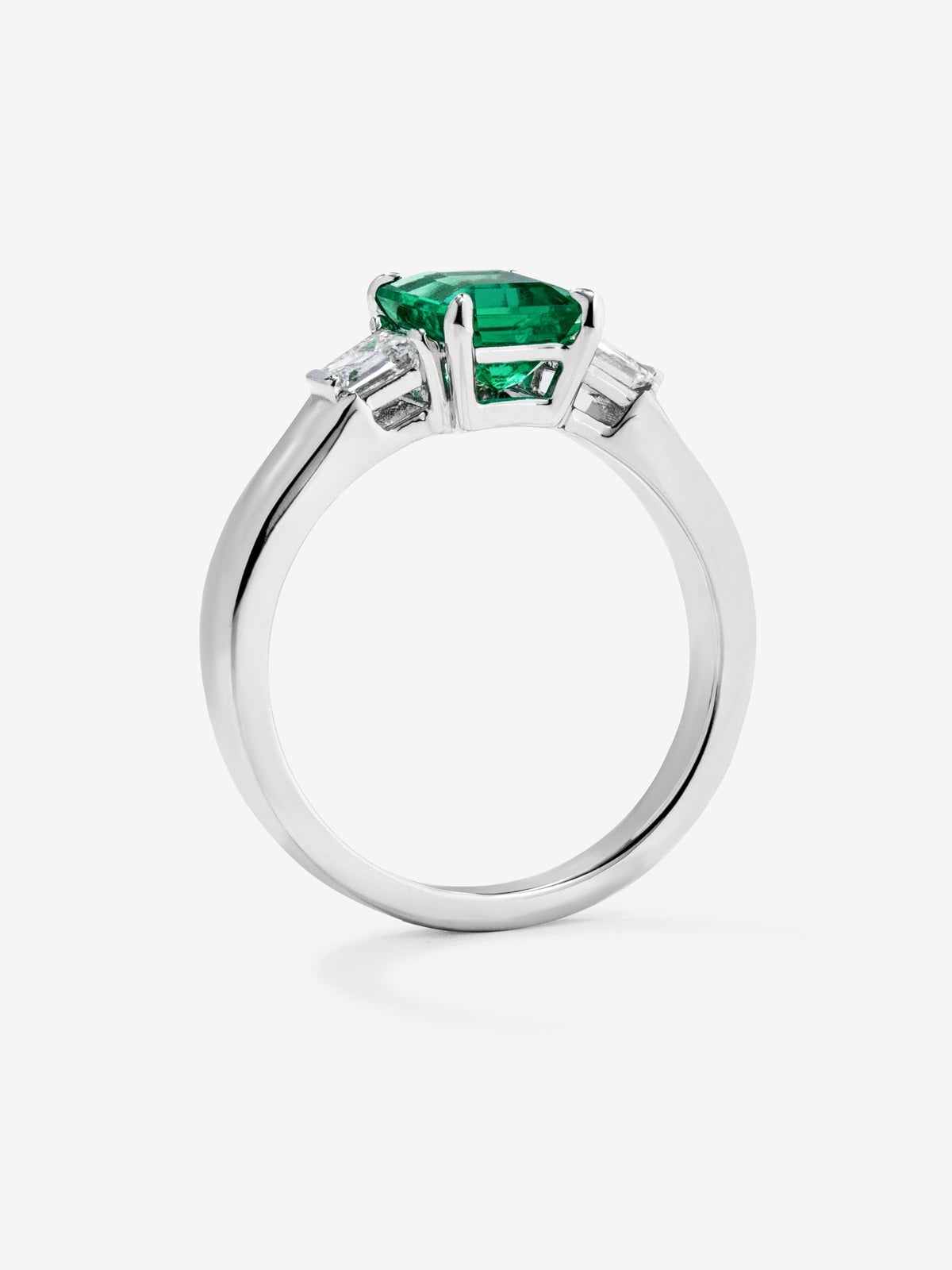 Anillo tresillo de oro blanco de 18K con esmeralda verde vivid en talla esmeralda de 1,64 cts y 2 diamantes blancos en talla fantasía con un total de 0,4 cts
