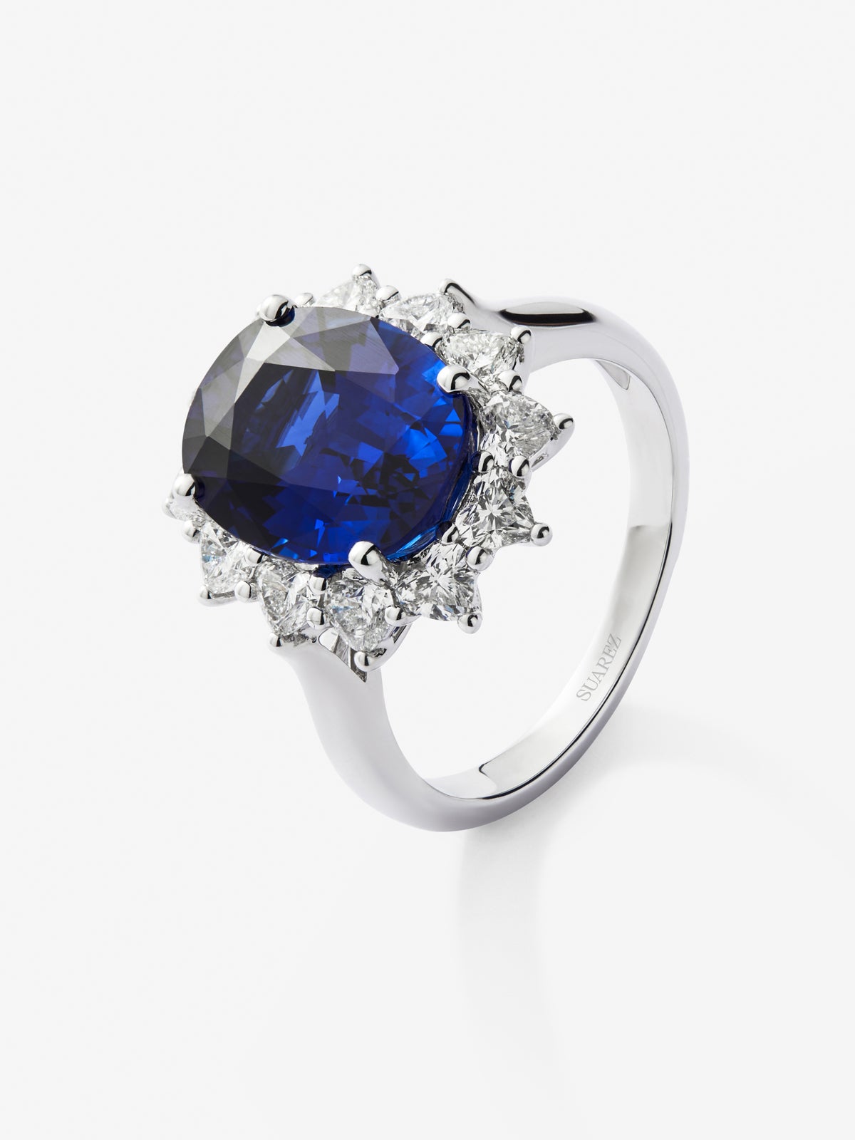 Anillo de oro blanco de 18K con zafiro azul vivid en talla oval de 5,01 cts y 10 diamantes en talla corazón con un total de 1,06 cts