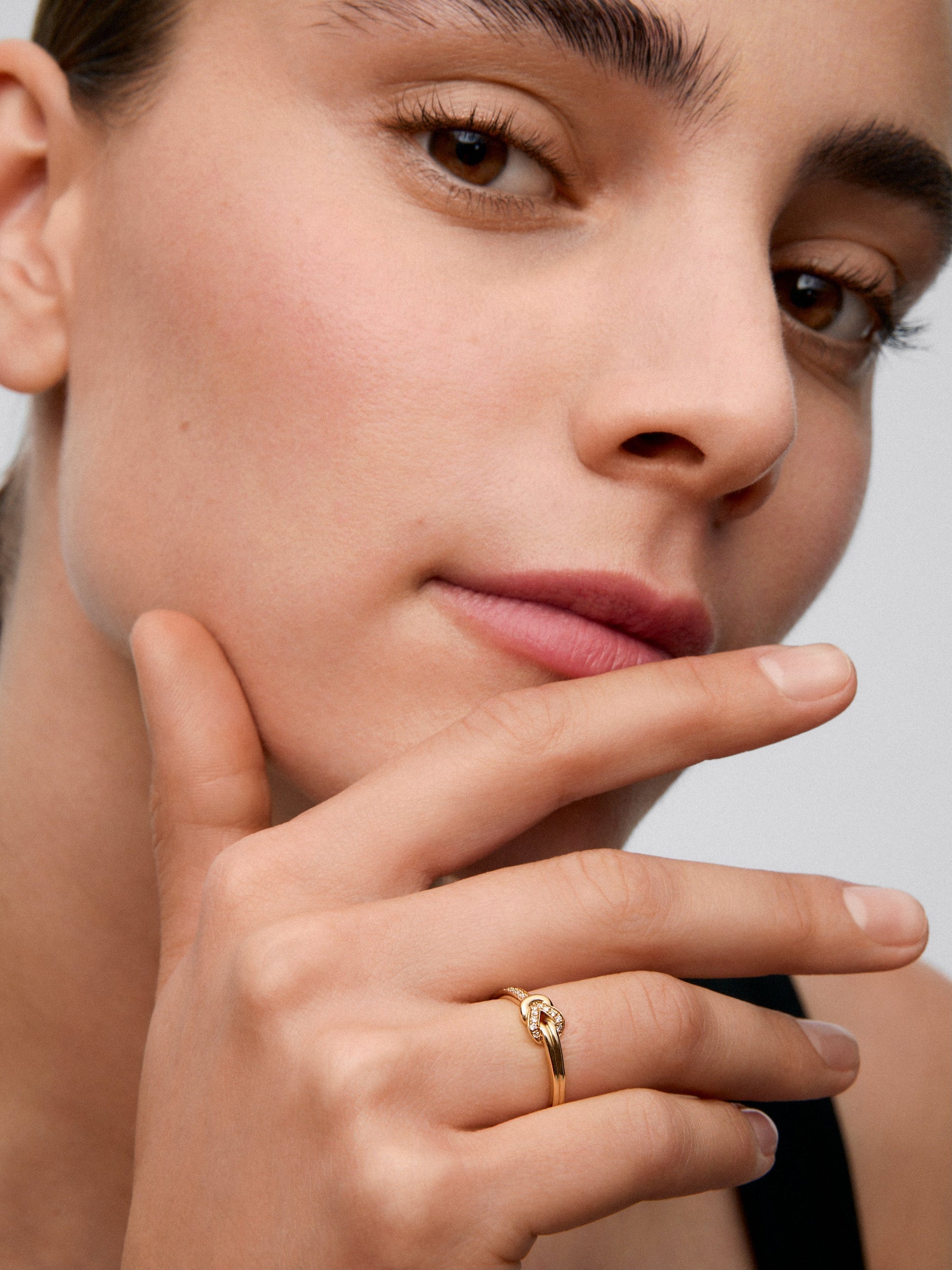 Anillo de oro amarillo de 18K con 15 diamantes en talla brillante con un total de 0,09 cts y forma de nudo