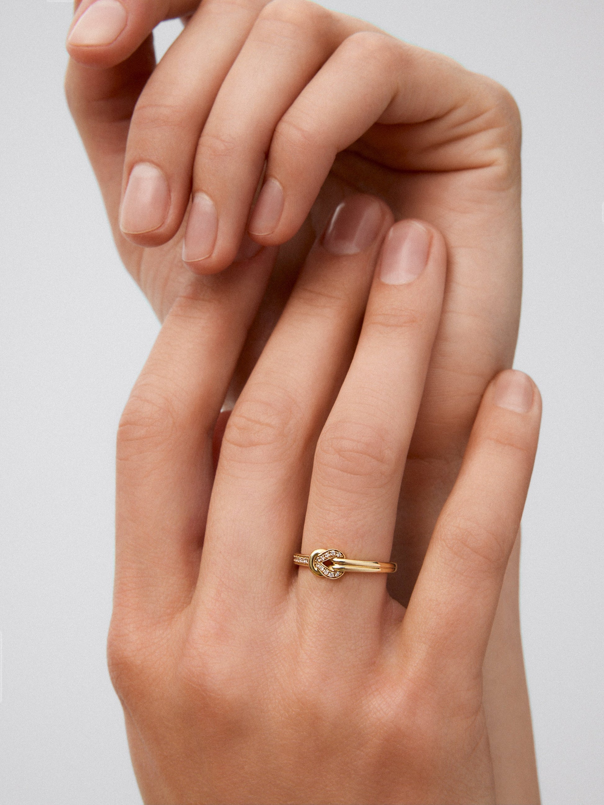 Anillo de oro amarillo de 18K con 15 diamantes en talla brillante con un total de 0,09 cts y forma de nudo