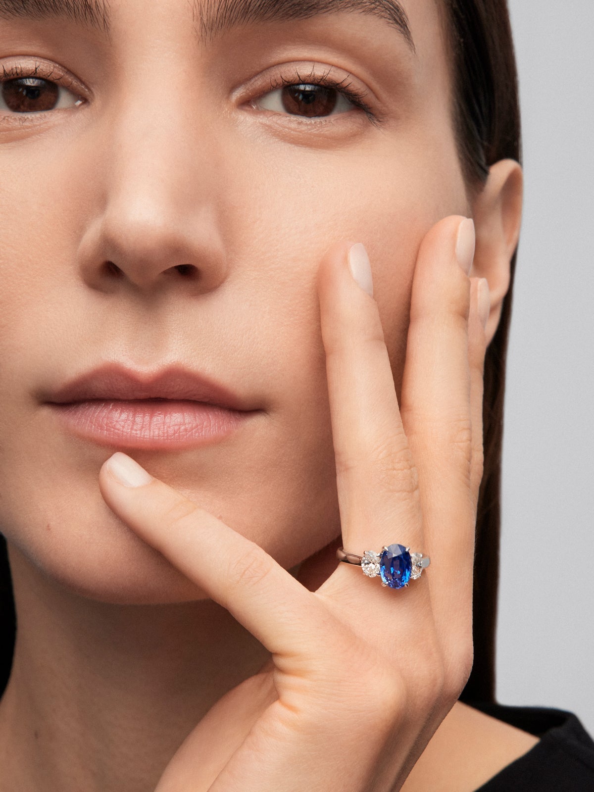 Anillo tresillo de oro blanco de 18K con zafiro azul royal en talla oval de 3,37 cts y 2 diamantes en talla oval con un total de 0,8 cts