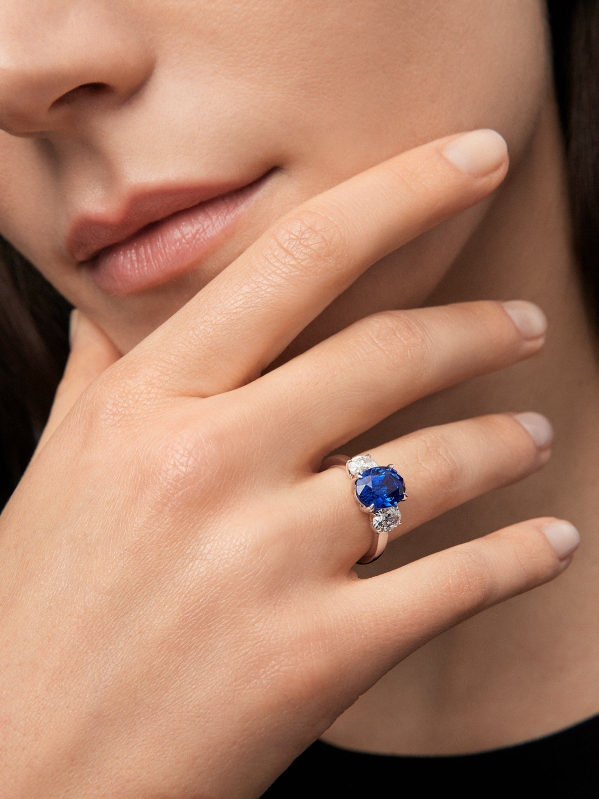Anillo tresillo de oro blanco de 18K con zafiro azul royal en talla oval de 4,05 cts y 2 diamantes en talla oval con un total de 1,05 cts