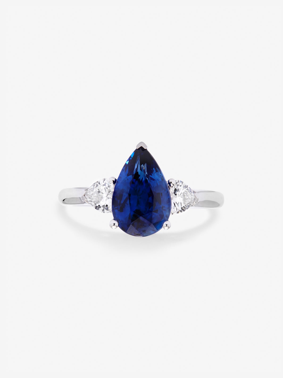 Anillo de oro blanco de 18K con zafiro azul royal en talla pera de 2,54 cts y 2 diamantes en talla corazón con un total de 0,38 cts