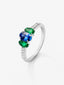 Anillo tresillo de oro blanco de 18K con zafiro azul en talla oval de 0,72 cts, 2 esmeraldas verdes en talla oval con un total de 0,36 cts y 16 diamantes en talla brillante con un total de 0,14 cts