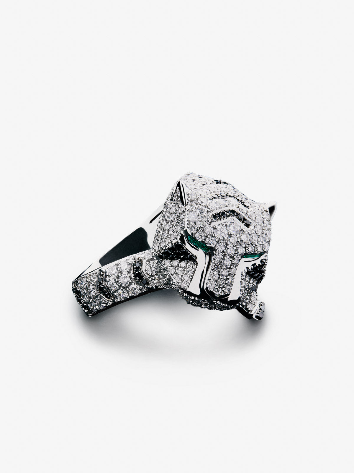 Anillo con forma de tigre en oro blanco de 18K con diamantes blancos y negros en talla brillante con un total de 2,12 cts y 2 esmeraldas en talla trapecio con un total de 0,13 cts