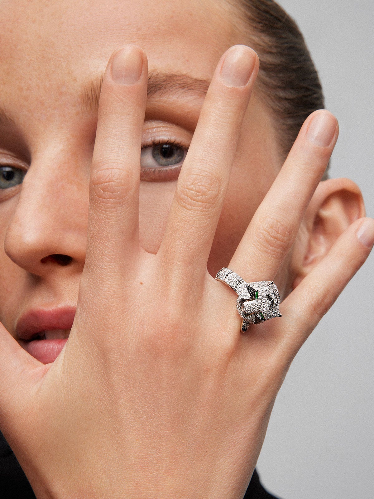 Anillo de oro blanco de 18K con 278 diamantes blancos en talla brillante con un total de 1,87 cts, 55 diamantes negros en talla brillante con un total de 0,25 cts, y 2 esmeraldas en talla trapecio con un total de 0,13 cts con forma de tigre