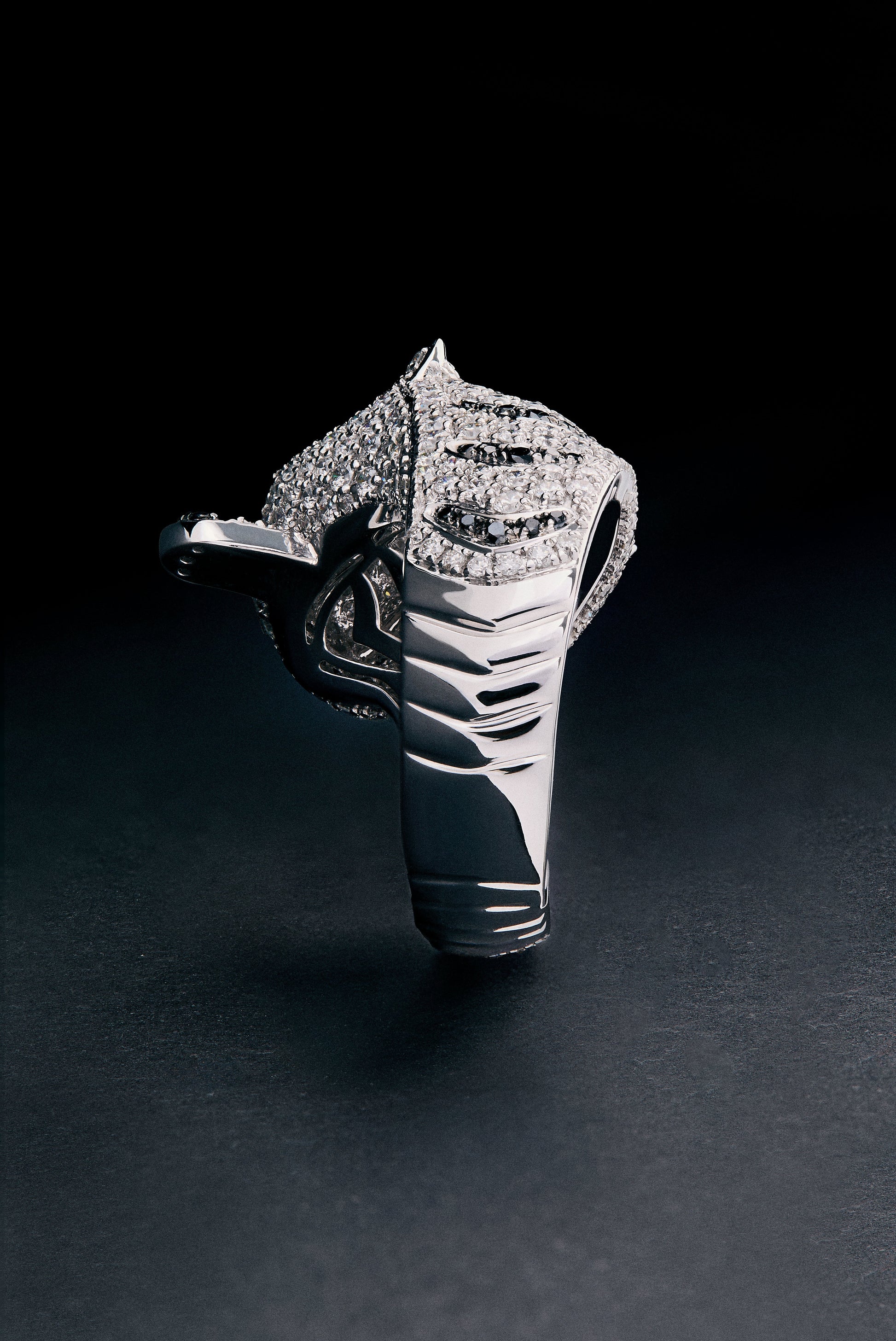 Anillo de oro blanco de 18K con 278 diamantes blancos en talla brillante con un total de 1,87 cts, 55 diamantes negros en talla brillante con un total de 0,25 cts, y 2 esmeraldas en talla trapecio con un total de 0,13 cts con forma de tigre