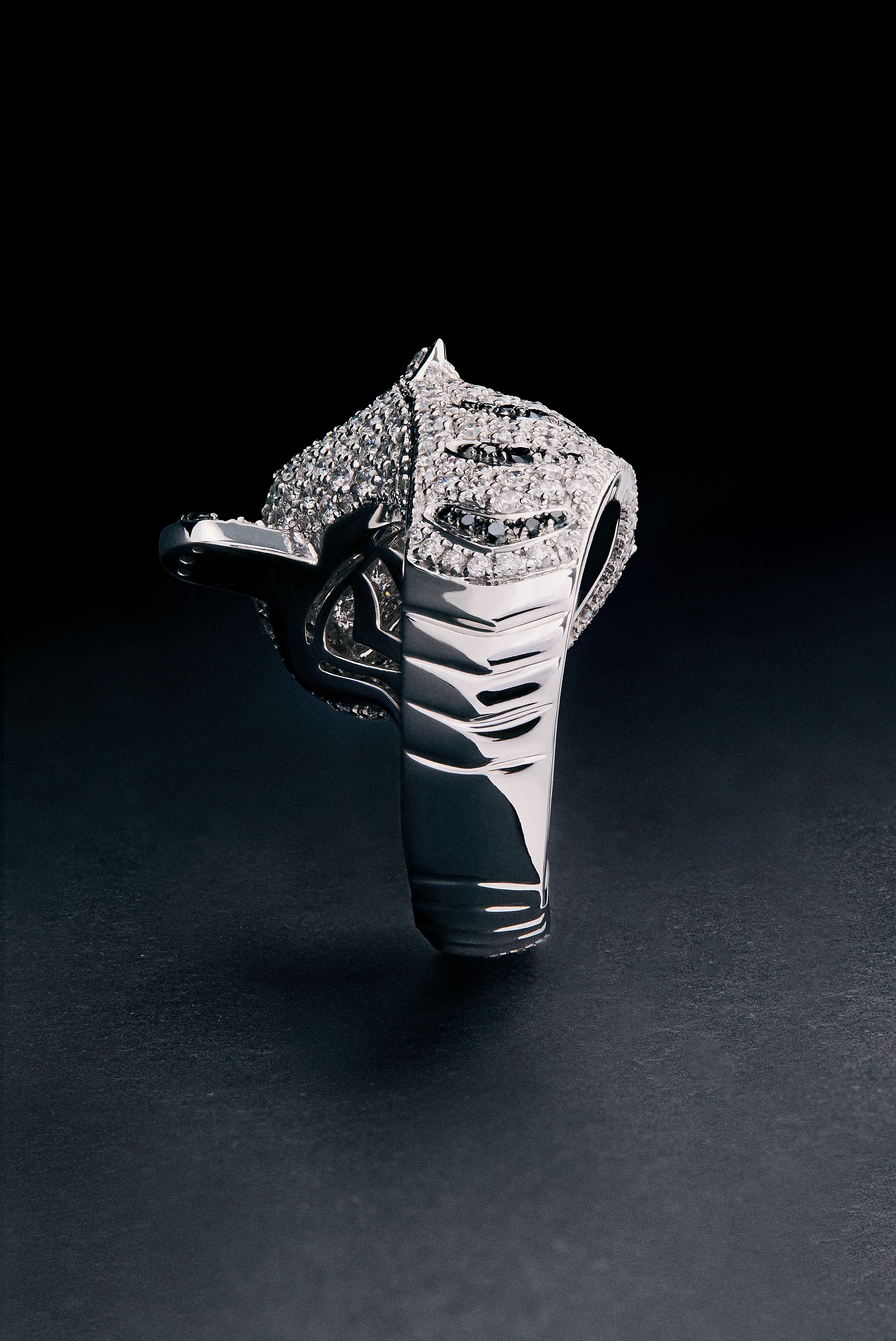 Anillo de oro blanco de 18K con 278 diamantes blancos en talla brillante con un total de 1,87 cts, 55 diamantes negros en talla brillante con un total de 0,25 cts, y 2 esmeraldas en talla trapecio con un total de 0,13 cts con forma de tigre