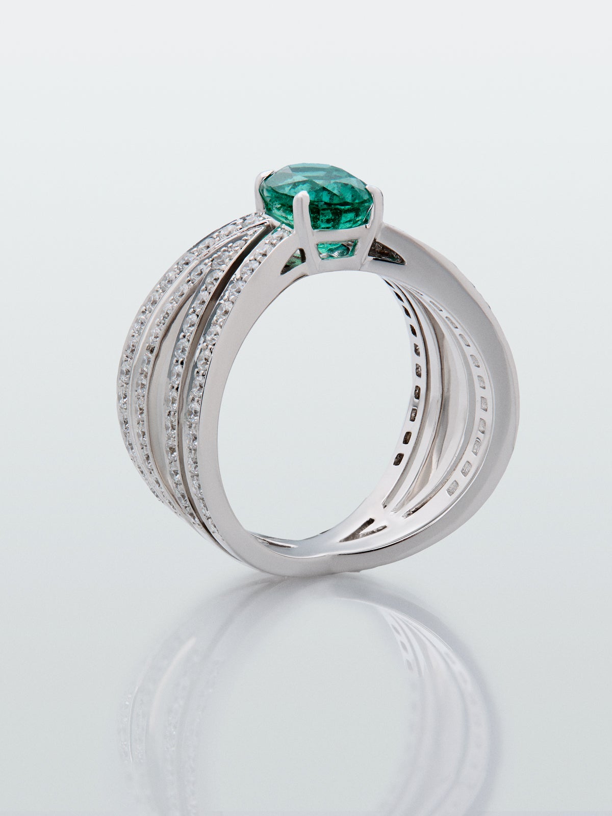 Anillo multibrazo de oro blanco de 18K con esmeralda en talla oval de 1,4 cts y diamantes en talla brillante con un total de 0,98 cts
