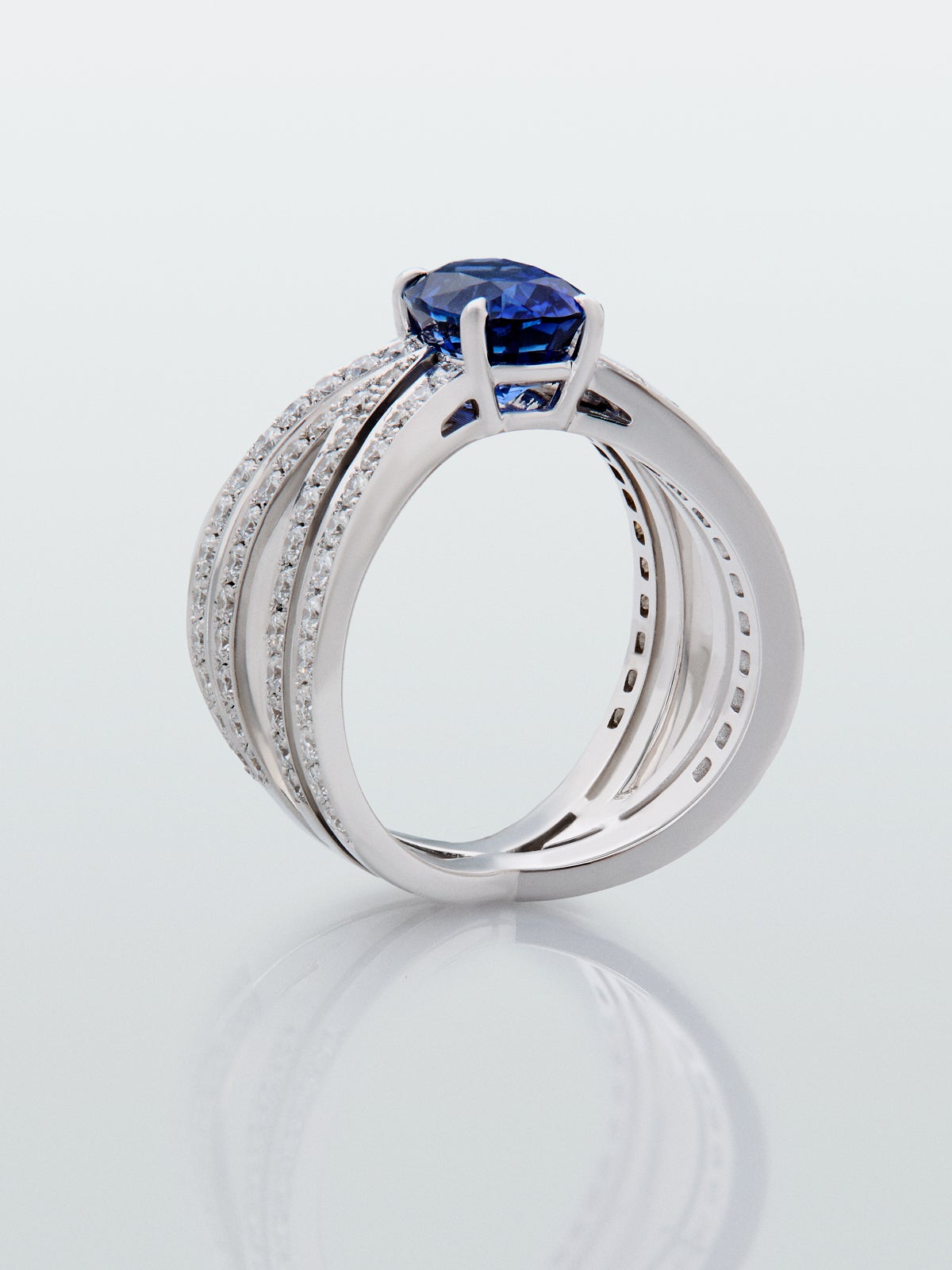 Anillo multibrazo de oro blanco de 18K con zafiro azul en talla oval de 2,47 cts y diamantes en talla brillante con un total de 1,09 cts