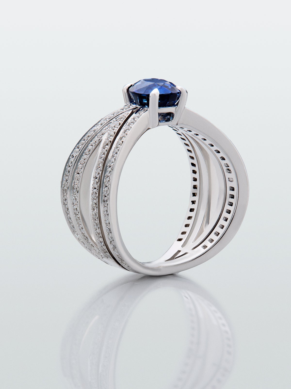 Anillo multibrazo de oro blanco de 18K con zafiro azul en talla oval de 1,8 cts y diamantes en talla brillante con un total de 0,71 cts