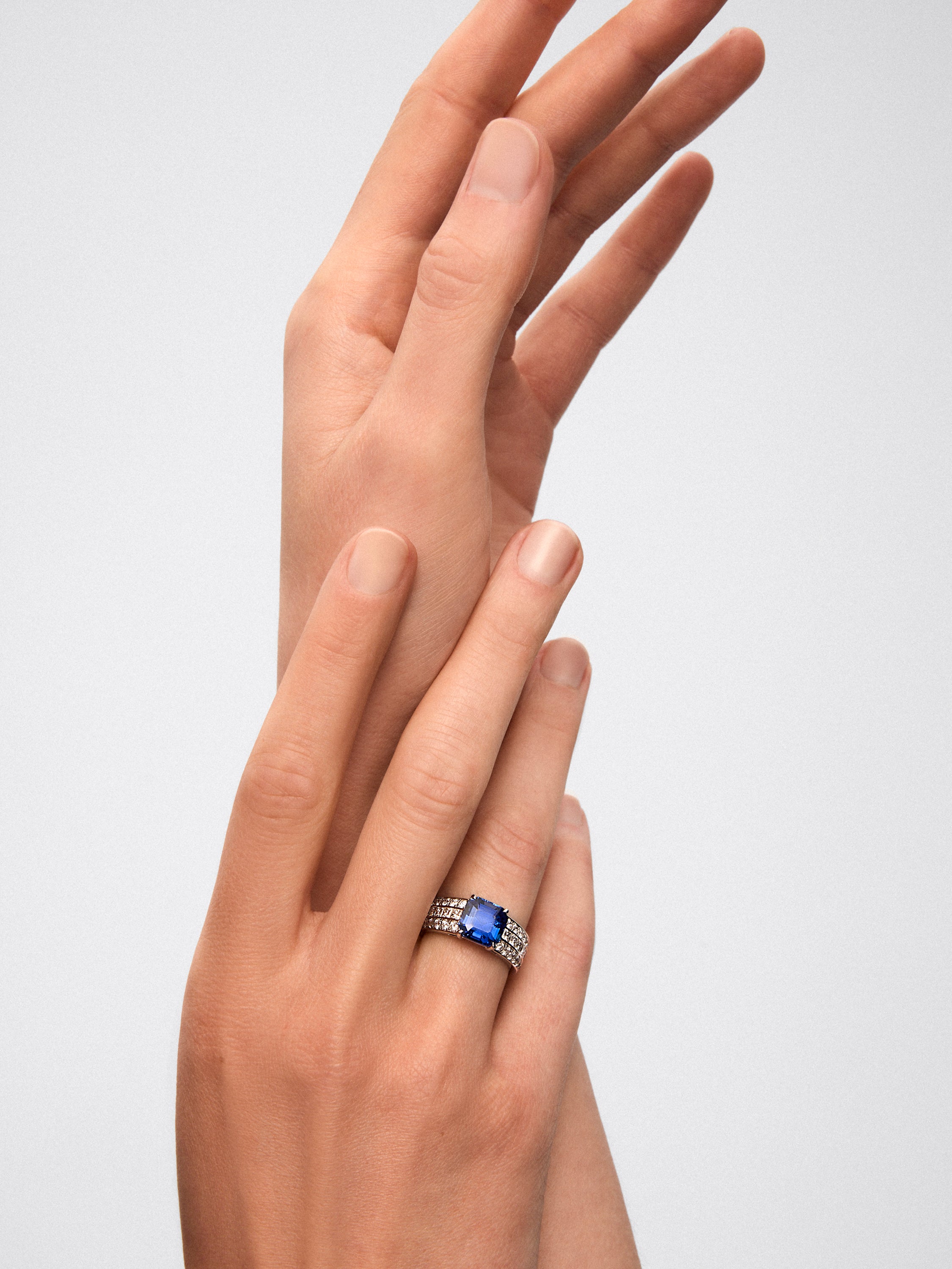 Anillo de oro blanco con zafiro central y brazo de diamantes