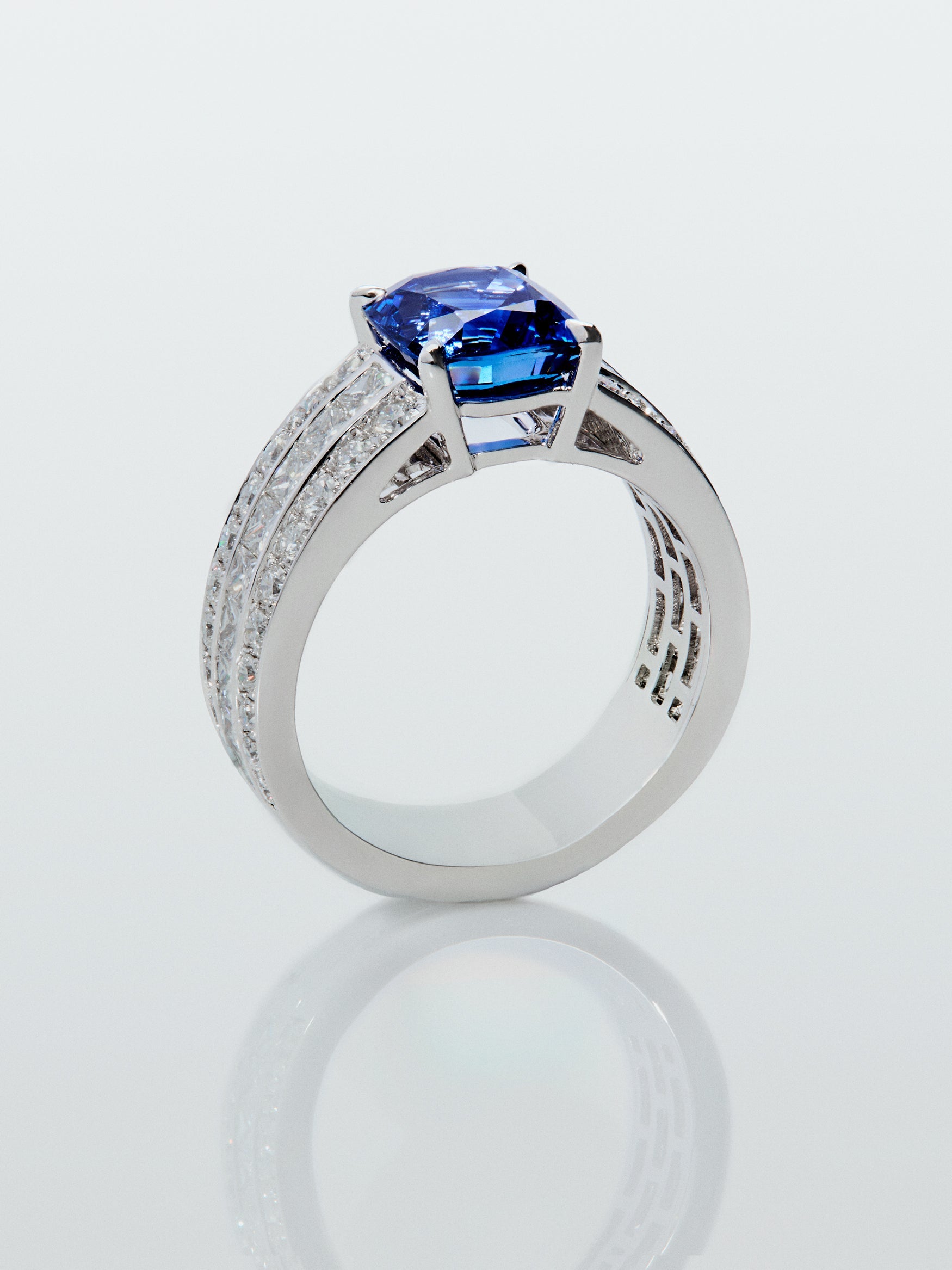 Anillo de oro blanco de 18K con zafiro azul royal en talla cushion de 3,217 cts, 50 diamantes en talla brillante con un total de 1,05 cts y 8 en talla princesa con un total de 0,48 cts