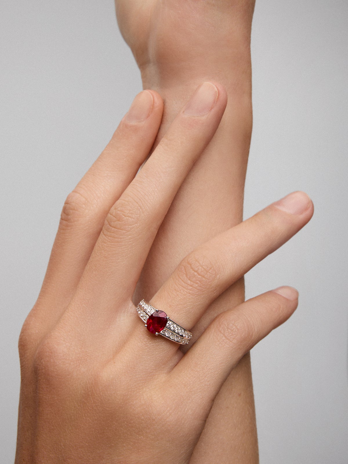 Anillo de oro blanco de 18K con rubí pigeon blood en talla oval de 1,489 cts y 32 diamantes en talla brillante con un total de 0,57 cts