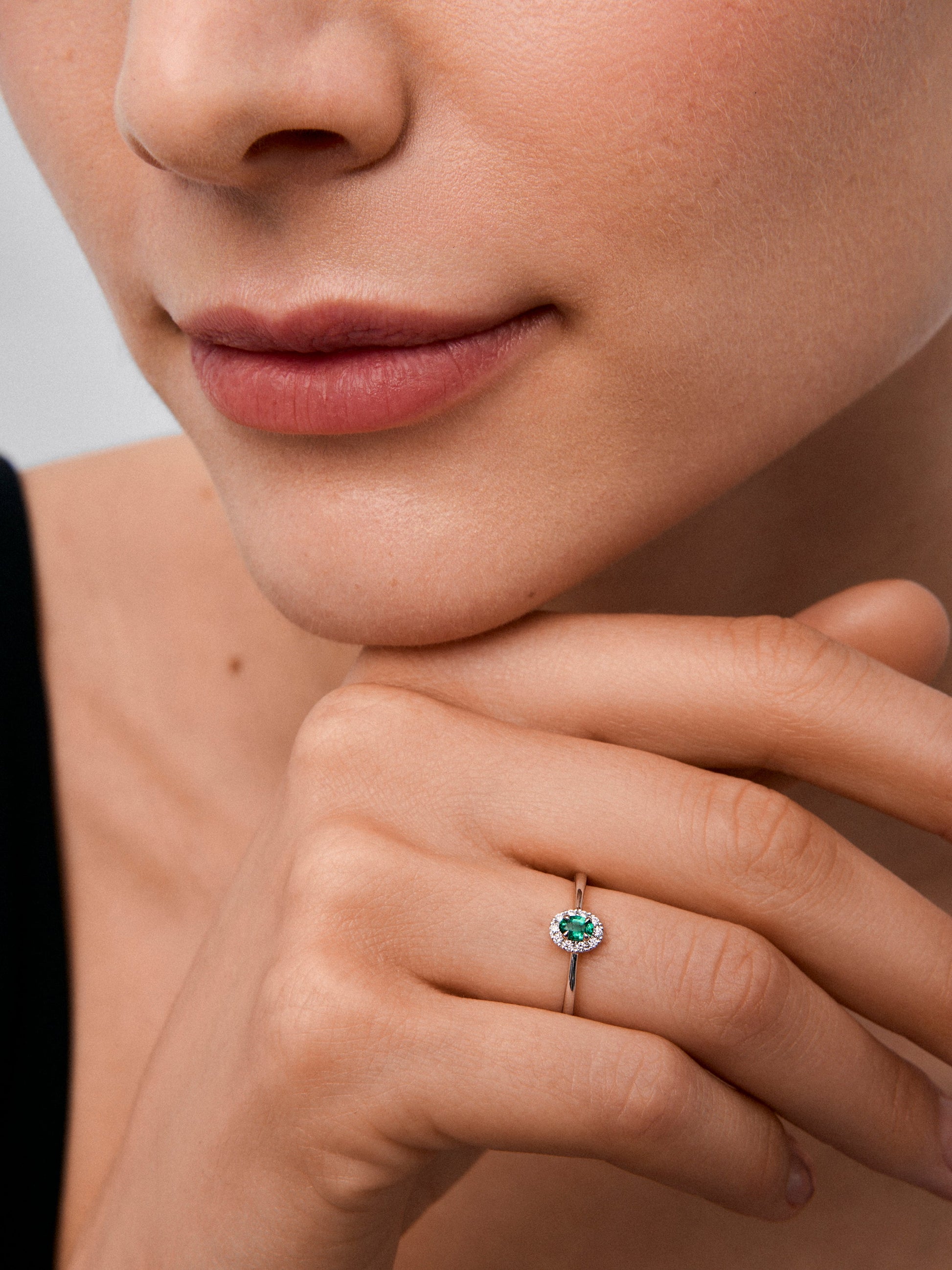 Anillo de oro blanco de 18K con esmeralda en talla oval de 0,2 cts y 10 diamantes en talla brillante con un total de 0,08 cts