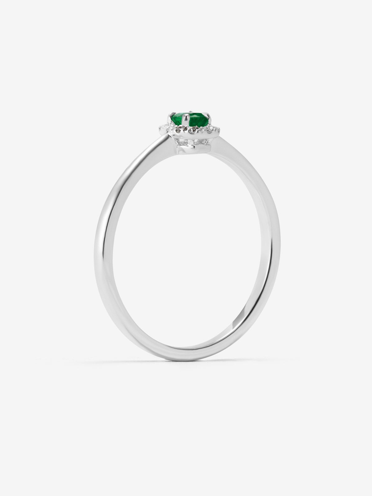 Anillo de oro blanco de 18K con esmeralda en talla oval de 0,2 cts y 10 diamantes en talla brillante con un total de 0,08 cts